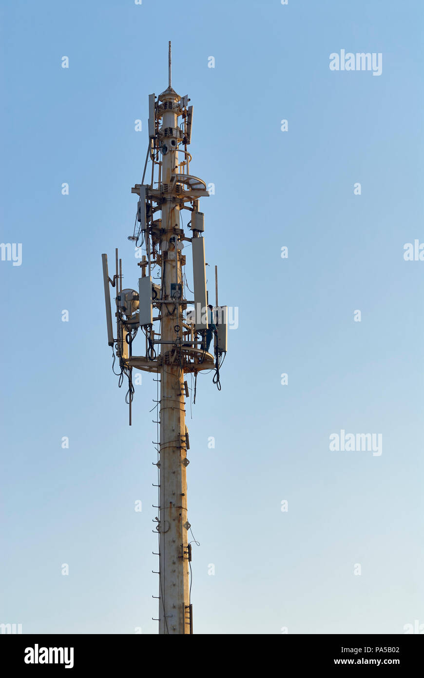 Queretaro, ver/MESSICO - Luglio 18, 2018: una persona fornisce interventi di manutenzione per un arrugginito cellular telecommunications tower vicino alla riva Foto Stock