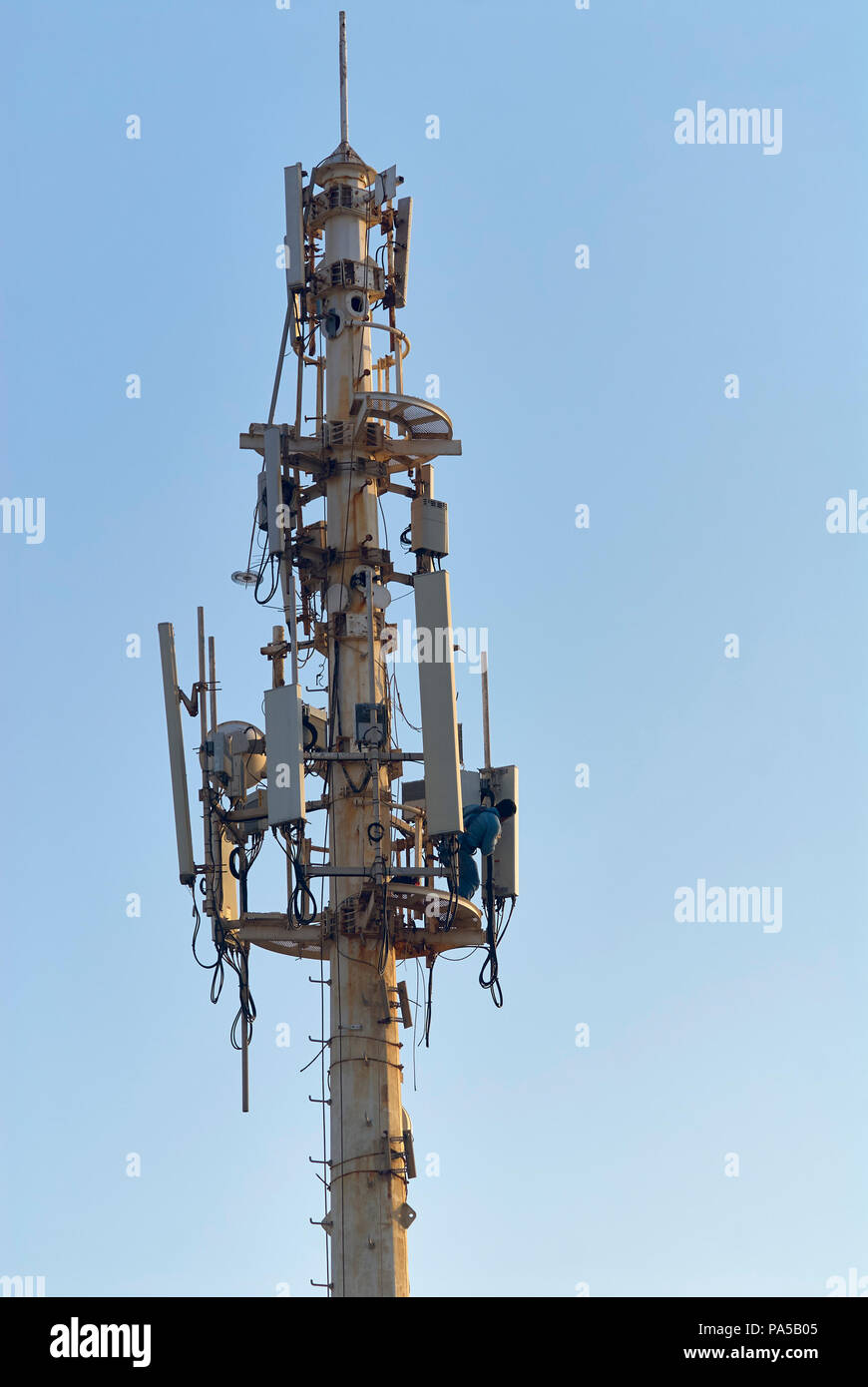 Queretaro, ver/MESSICO - Luglio 18, 2018: una persona fornisce interventi di manutenzione per un arrugginito cellular telecommunications tower vicino alla riva Foto Stock