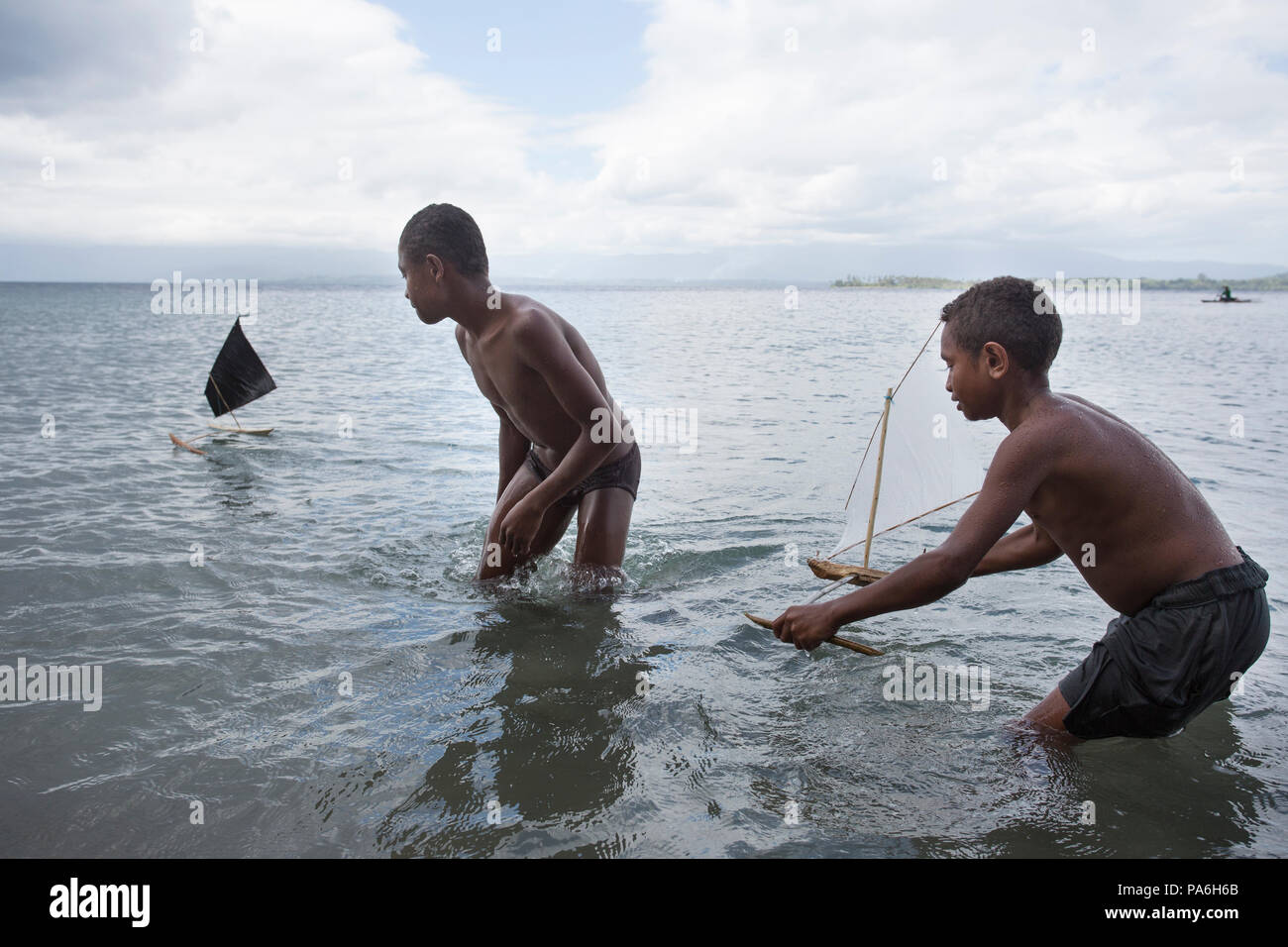 Ragazzi giocare con toy barche, Papua Nuova Guinea Foto Stock