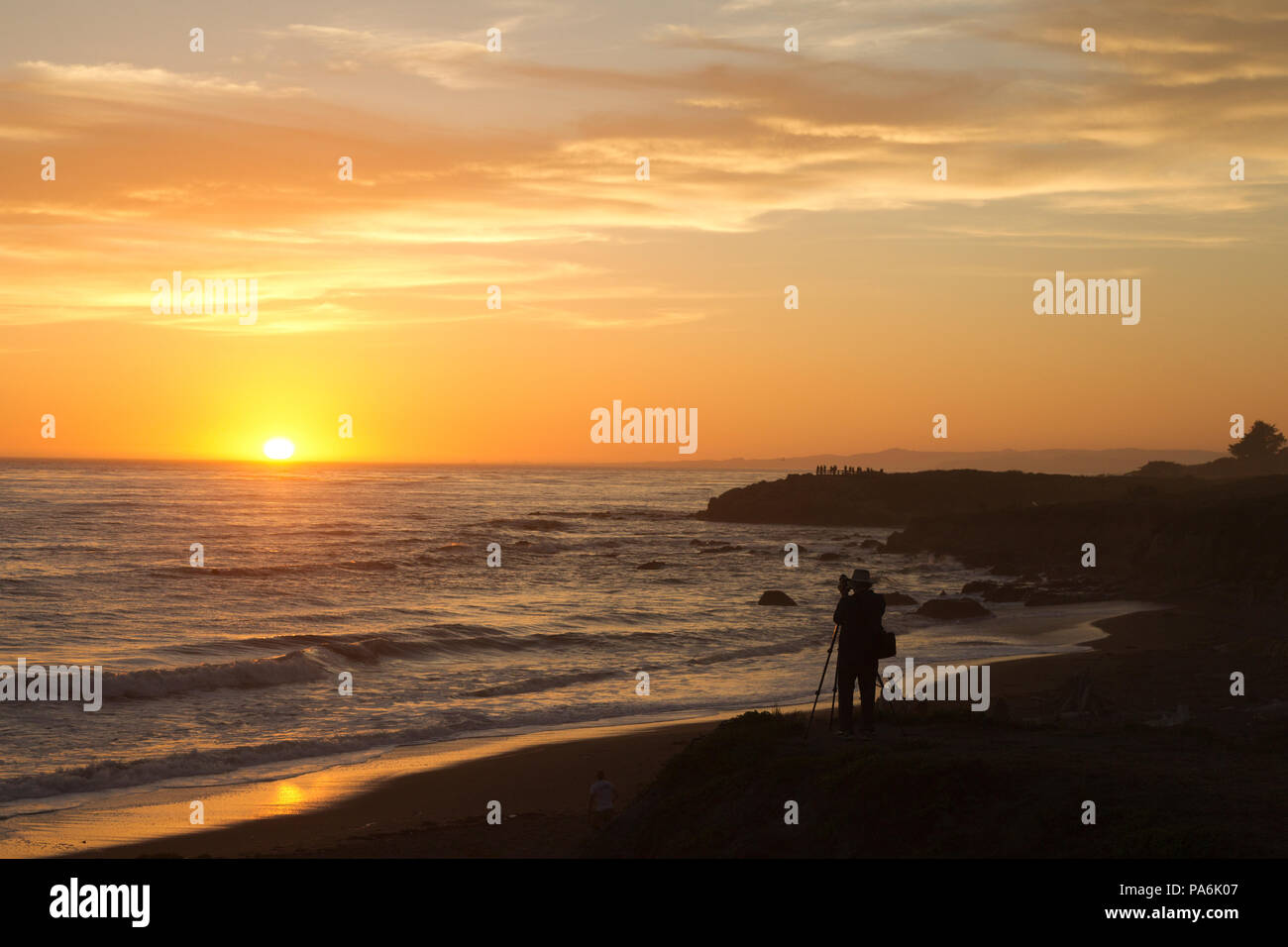 Uomo di fotografare il tramonto oltre oceano pacifico Foto Stock