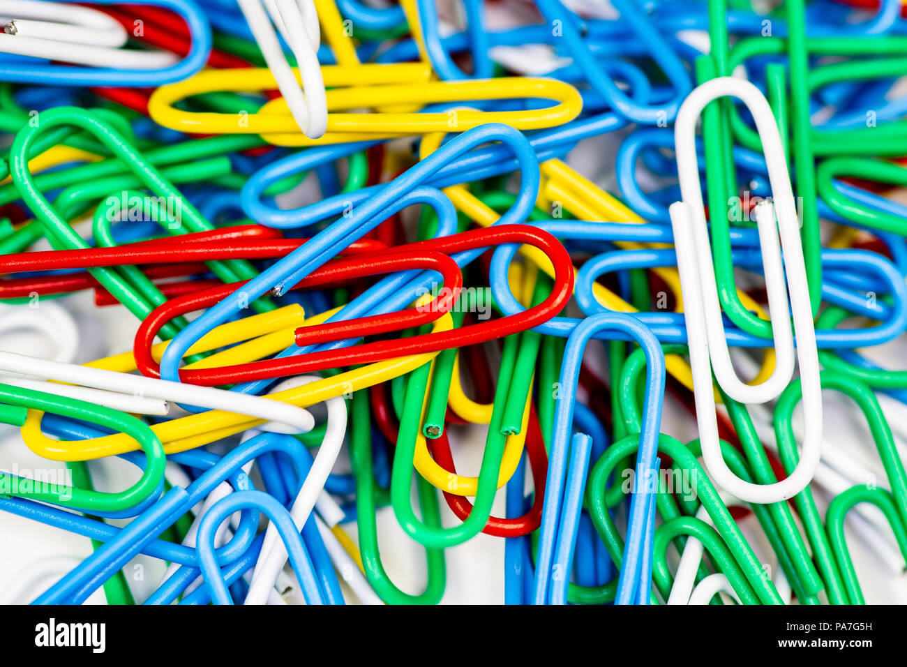 Colorato graffette affastellati su una superficie bianca. Foto Stock