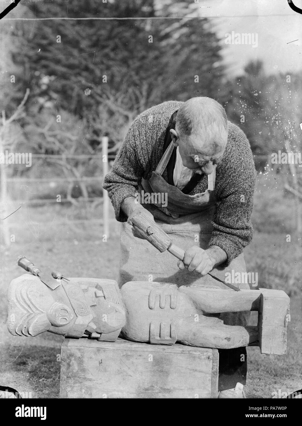 14 Albert Percy Godber a lavorare su un intaglio nella tradizione Maori, circa 1930 ATLIB 306456 Foto Stock