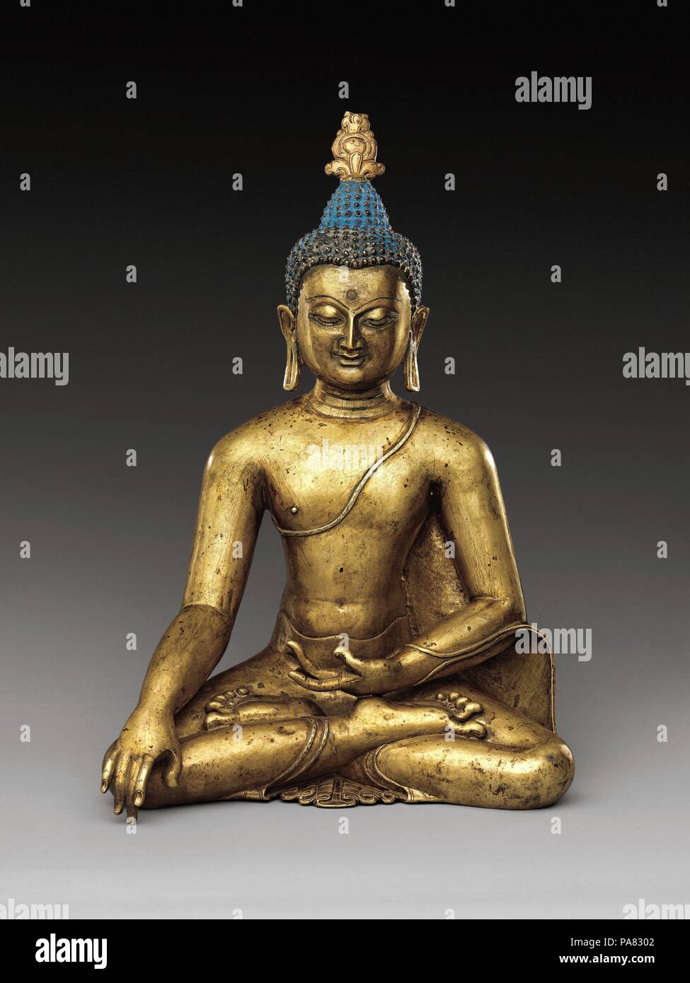 Buddha Sakyamuni. Cultura: Tibet Centrale. Dimensioni: H. 15 1/2 in. (39,4 cm); W. 10 7/16 in. (26,5 cm); D. 8 5/8 in. (21,9 cm). Data: ca. Xii secolo. Questa è una sublime e rara raffigurazione tibetana del Buddha storico. Seduti in meditazione yogiche, egli i gesti per la terra a testimoniare il momento della sua illuminazione. Egli mostra segni di buon auspicio di buddhità (lakshanas), compreso il orecchioni estesa, fronte mark e protuberanza del cranio. Le sottili sfumature di espressione facciale e articolata dita delle mani e dei piedi di aggiungere una dimensione umana per questo altrimenti piuttosto astratto e ethereal Buddha im Foto Stock