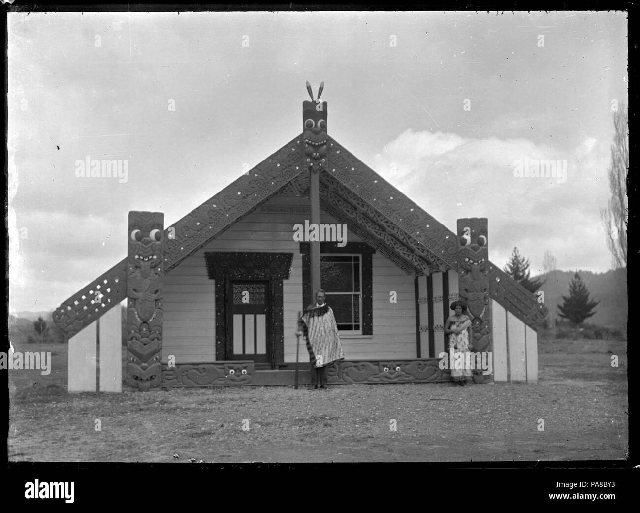50 Chief Matekuare e sua figlia Tuki al di fuori di un meeting house a Te Whaiti, 1930 ATLIB 298818 Foto Stock