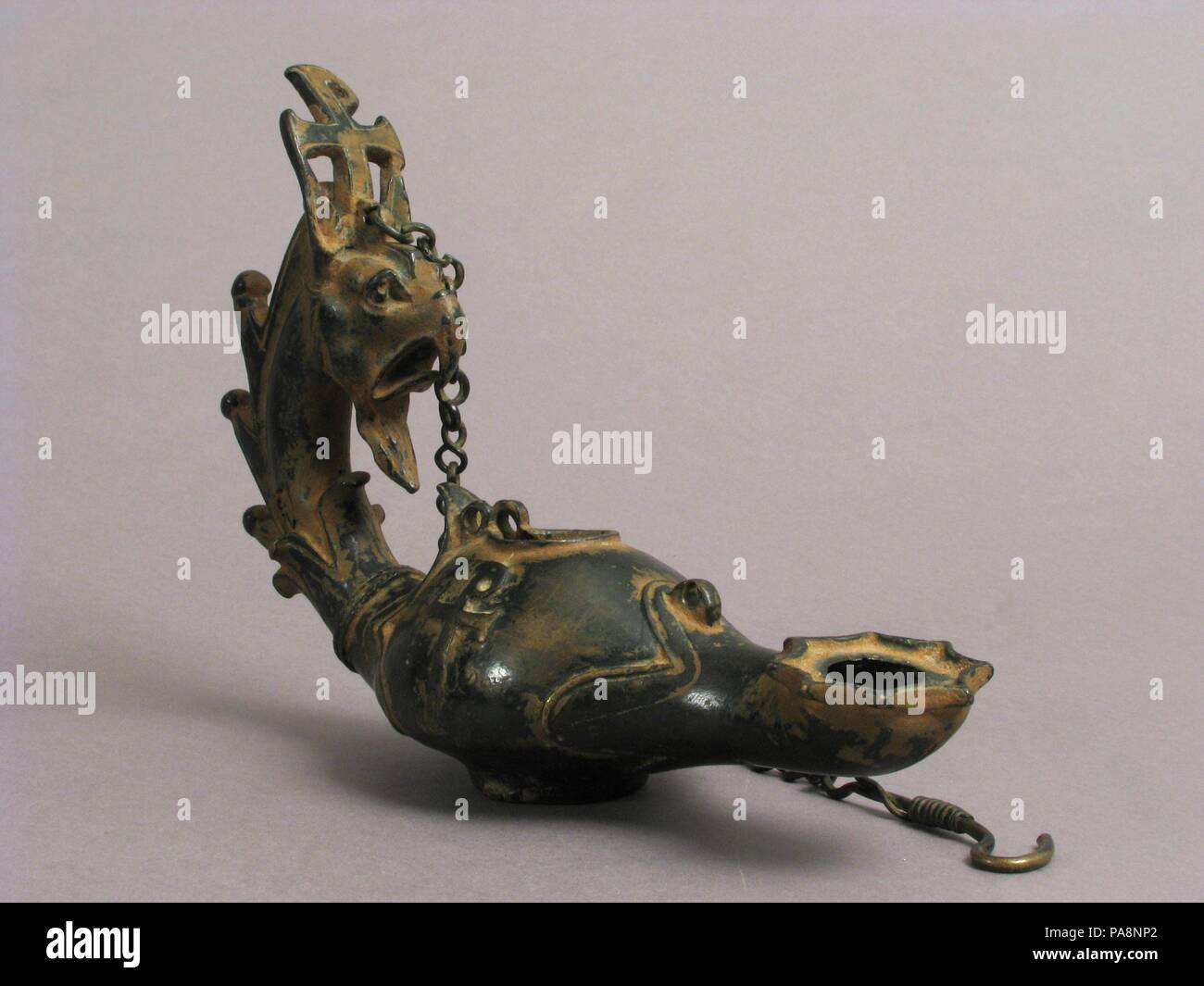 Lampadario con un grifone alla testa. Cultura: bizantina. Dimensioni: complessivo: 6 1/2 x 9 3/16 x 3 1/16 in. (16.5 x 23.3 x 7.7 cm) catena lunghezza: 12 3/8 in. (31,4 cm). Data: 4a-6a secolo. Questo griffin, un mitico bestia associati nel mondo classico con luce e protezione, è stato adattato per uso cristiano mettendo sul suo lato una variazione del Chi-Rho Christogram, il monogramma per il nome di Cristo. Museo: Metropolitan Museum of Art di New York, Stati Uniti d'America. Foto Stock