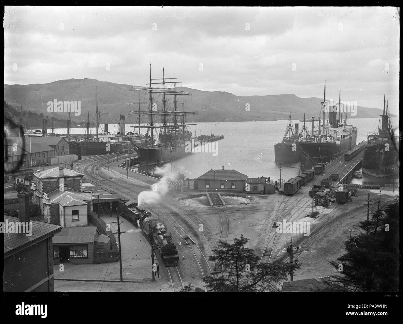 111 Harbor scena, probabilmente a Port Chalmers, con diverse navi ormeggiate presso i pontili tra cui l'acciaio 4 masted barque "Olivebank" ATLIB 292537 Foto Stock