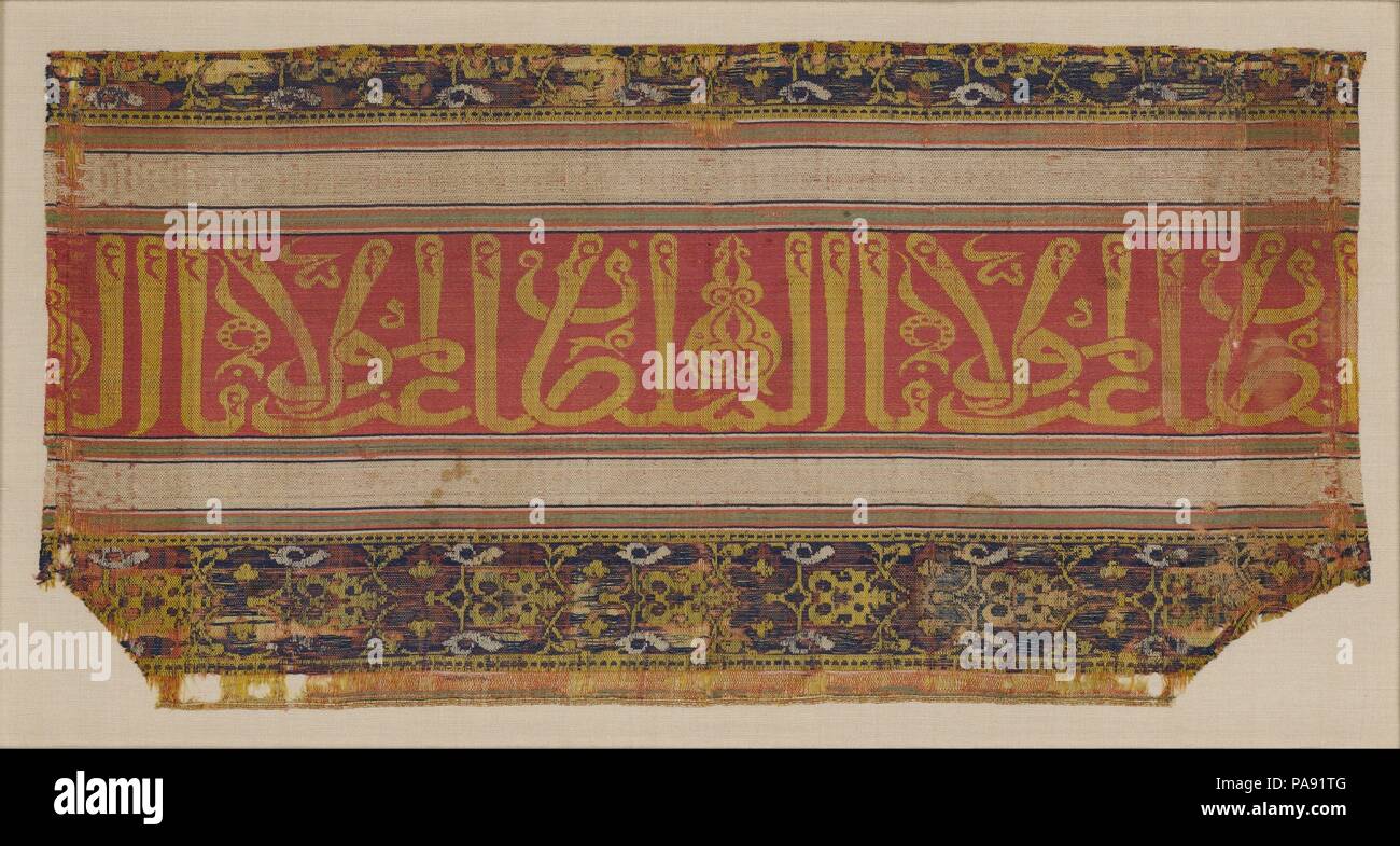 Frammento di tessili. Dimensioni: Tessile: L. 10 5/8 in. (27 cm) W. 21 1/4 in. (54 cm) Monte: L. 15 1/2 in. (39,4 cm) W. 26 a. (66 cm) D. 1 3/4 in. (4.4 cm). Data: tardo XIV-XV secolo. Questo frammento di tessuto, tessuto in colorate vivacemente seta, è ornata con un Arabo iscrizione in corsivo thuluth script, che recita "gloria al nostro signore il sultano." Questa frase è stata spesso impiegati nella nobilitazione delle arti e architettura del periodo Nasrid, e molti prodotti tessili simili oggi sopravvivono come frammenti. Tessuto di seta realizzato in al-Andalus per sontuosi costumi e arredamento costosi Foto Stock