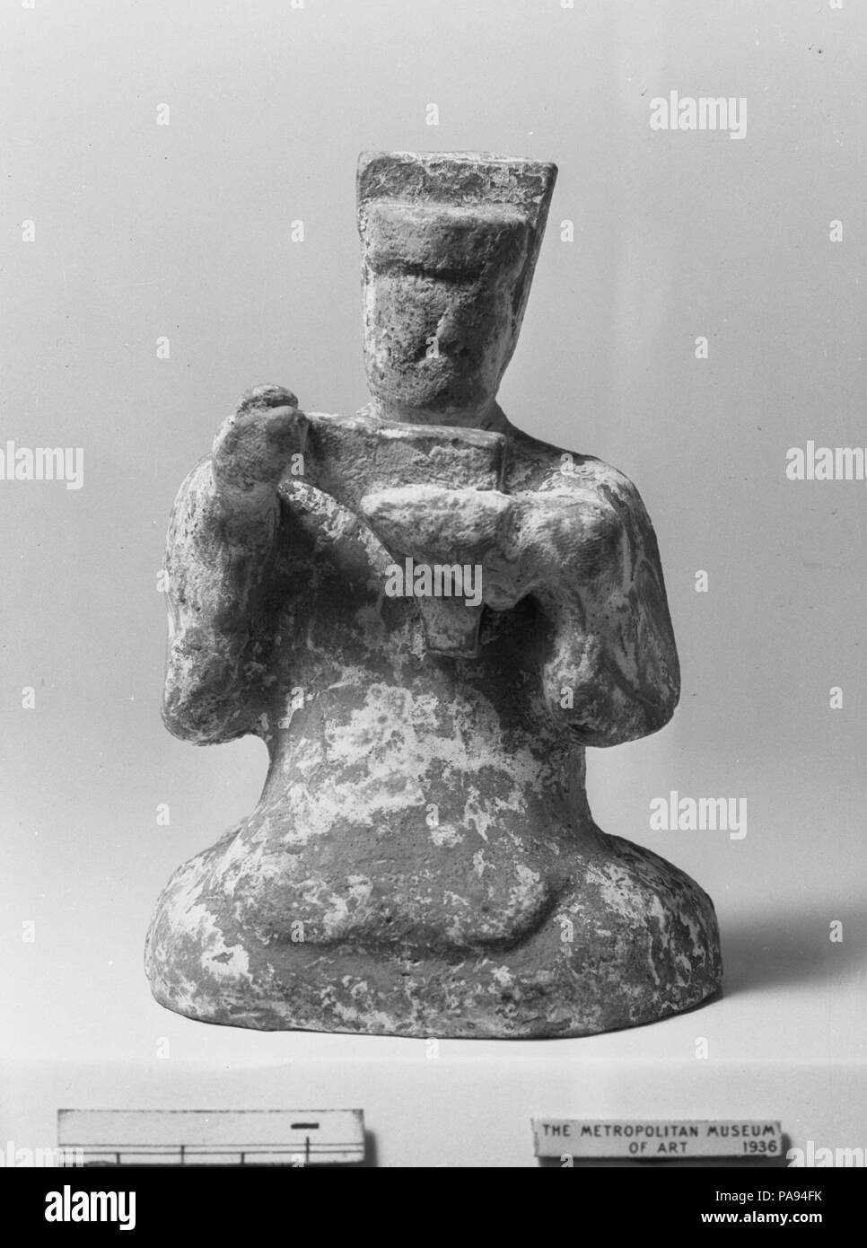 La figura dell animatore. Cultura: la Cina. Dimensioni: H. 3 1/2 in. (8.9 cm). Gli strumenti musicali rappresentati tra questo gruppo di figure in ceramica (36.12.1, .2, .10-.13, .16) sono tipici di quelli utilizzati nella musica popolare del periodo Han (206 A.C.-A.D. 220). Gli strumenti erano tutte lunghe storie, avendo esistito per secoli, nel caso della cetra, o millenni, nel caso del flauto (oggi mancante dalla figura del flautista). Museo: Metropolitan Museum of Art di New York, Stati Uniti d'America. Foto Stock