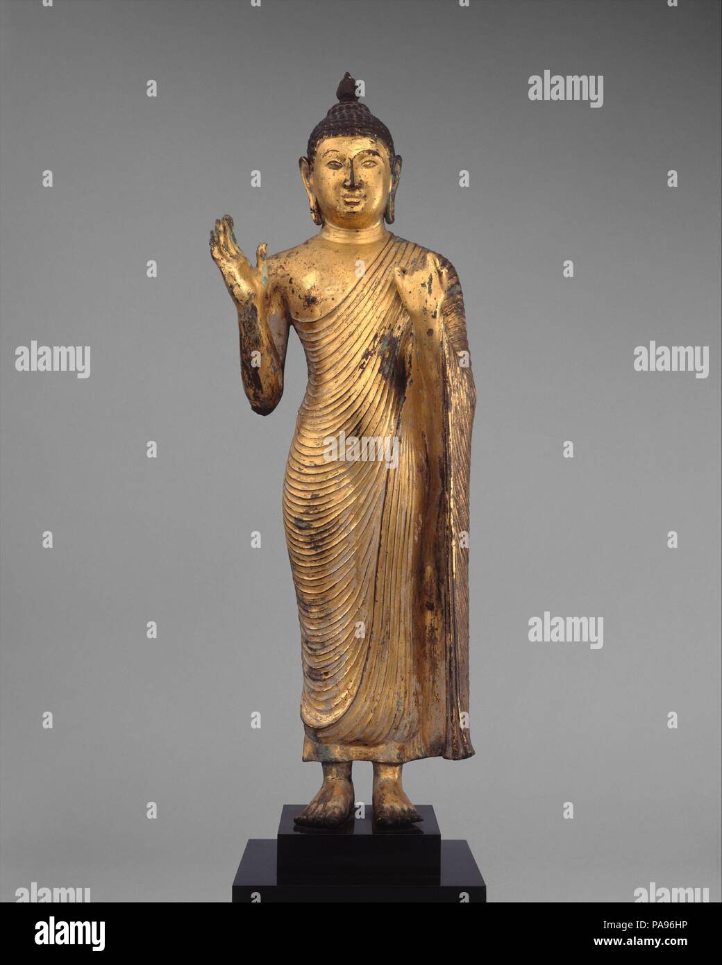 Il Buddha che offrono protezione. Cultura: Sri Lanka, altopiano centrale. Dimensioni: H. (figura) 23 3/4 in. (60,3 cm); W. 7. (17,8 cm); D. 4. (10,2 cm). Data: decimo secolo. Questo grande Buddha gesti protezione compassionevole per i devoti (abhaya mudra) con il suo sollevata destra, mentre la sua mano sinistra sostiene la caduta di spazzamento della sua tunica monastica (uttarsanga). Le caratteristiche del viso e contorno corporeo suggeriscono che il lavoro è un prodotto di primi Polonnaruva periodo. Museo: Metropolitan Museum of Art di New York, Stati Uniti d'America. Foto Stock