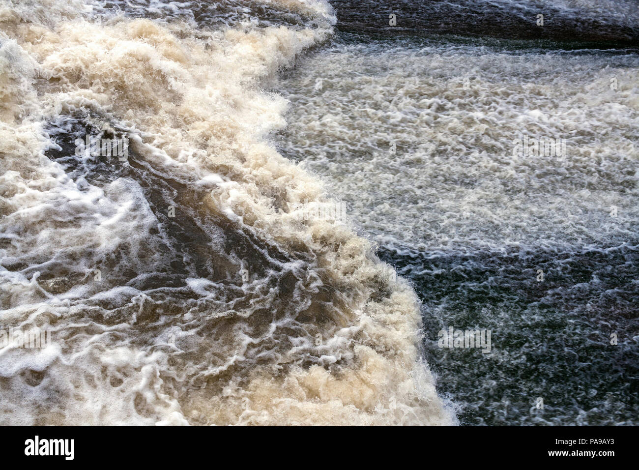 Potente flusso di schiumatura a gorgogliamento d'acqua. Messa a fuoco selettiva. Foto Stock