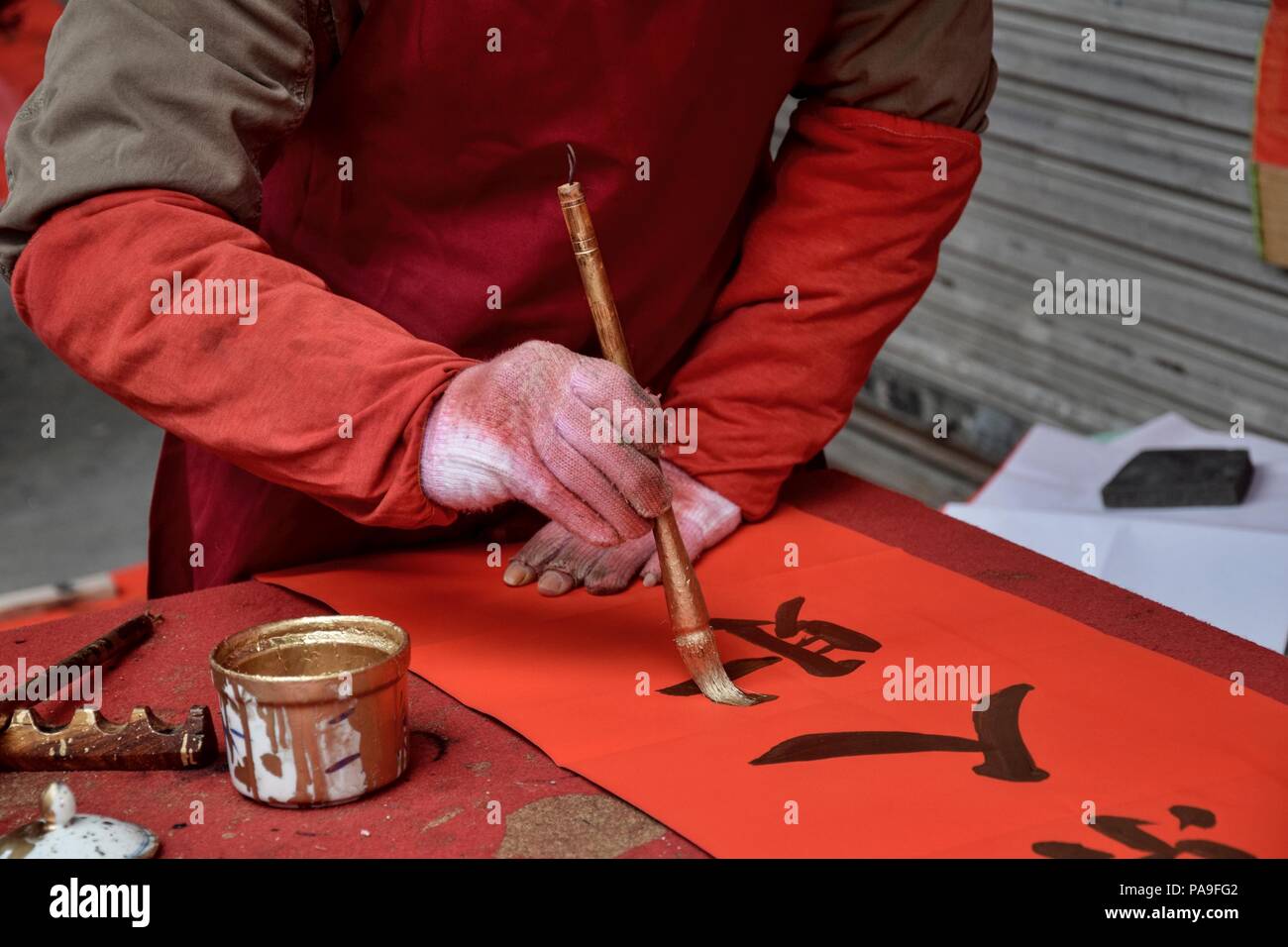 La calligrafia cinese scritto da un vecchio uomo prima che il nuovo anno cinese. Un carattere traduzione è persona. Foto Stock