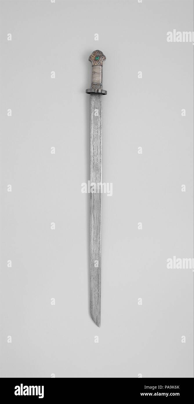 Spada (Ral gri). Cultura: tibetano. Dimensioni: L. 33 a. (83,8 cm); L. della lama 28 1/4 in. (71,8 cm); W. 2 1/2 in. (6,4 cm); D. 2 1/8 in. (5.4 cm); Wt. 2 lb. (907.2 g). Data: 17th del XIX secolo. Questa spada è un esempio rappresentativo della maggior parte familiare forma tibetana, ben fatti e di qualità abbastanza buona. La superficie della lama ha una forcina prominente pattern, una caratteristica importante della tradizionale tibetana di spade. Il modello si compone di sette linee scure alternate con sei linee di luce, causata dalla piegatura ripetuta di due differenti tipi di ferro che sono stati combinati per rendere la lama Foto Stock