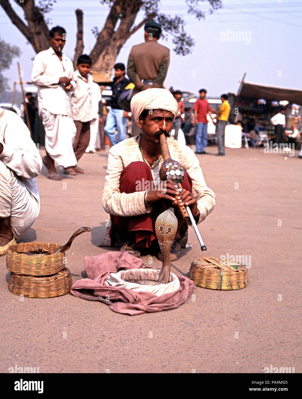 Il serpente incantatore allettante serpenti cobra fuori i loro cestini di vimini al di fuori della Red Fort, Delhi, Delhi il territorio dell' Unione, India. Foto Stock