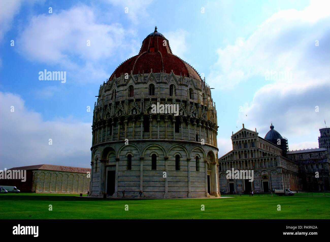 Un ampio angolo di visione del Battistero di Pisa in Italia e gli edifici dietro di essa Foto Stock