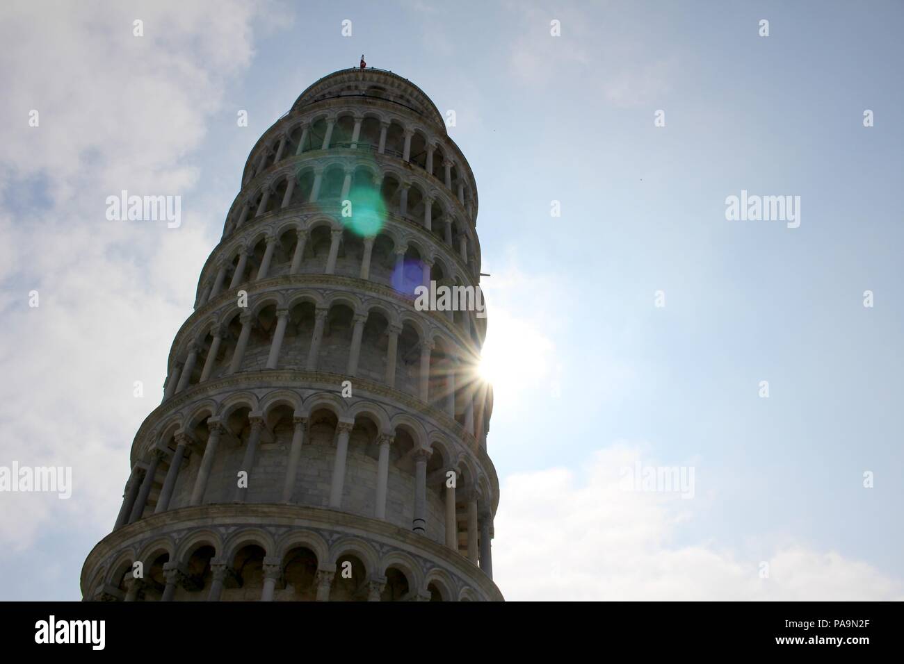 Una vista della Torre Pendente di Pisa, Italia e il sole nascosto dietro di essa Foto Stock