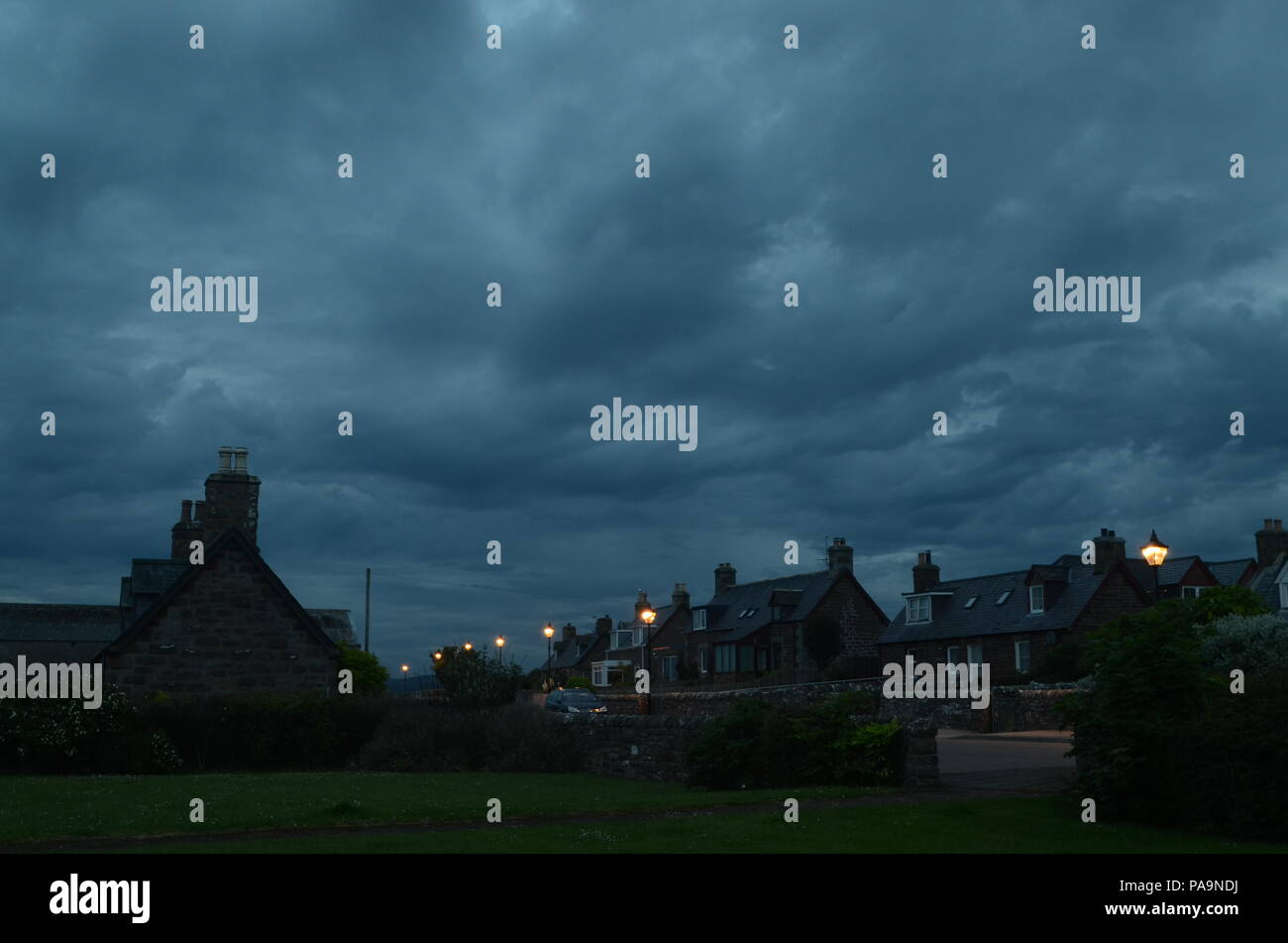 Dark nuvole sopra il villaggio di Golspie, Scozia Foto Stock