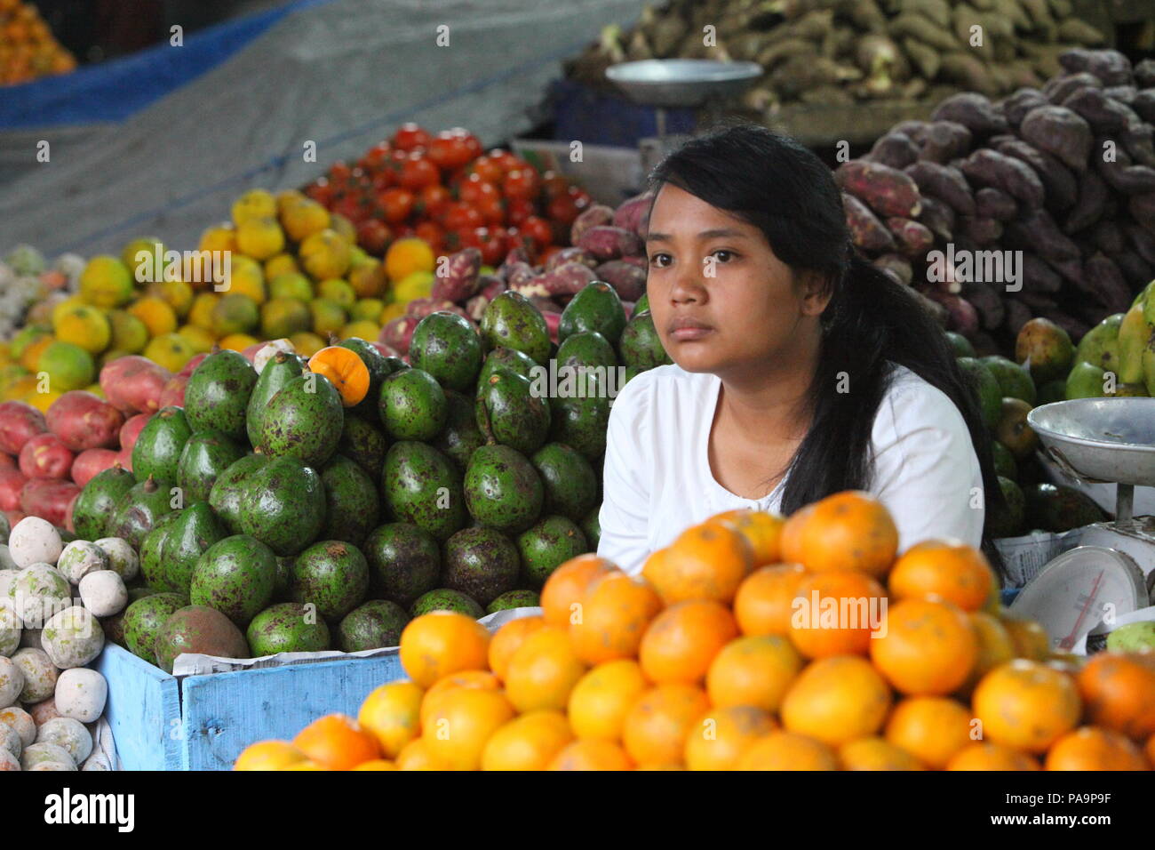 Una ragazza la vendita di frutta e verdura in un villaggio di mercato in Indonesia Foto Stock