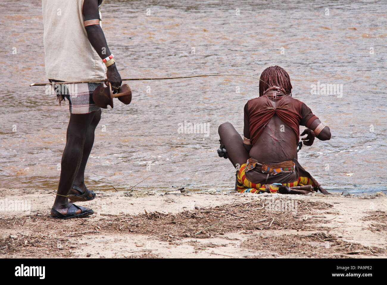 Un Hamar donna si siede sul fiume durante il Bull Jumping cerimonia (Ukuli rituale) da Hamer Hamar tribù, Etiopia Foto Stock