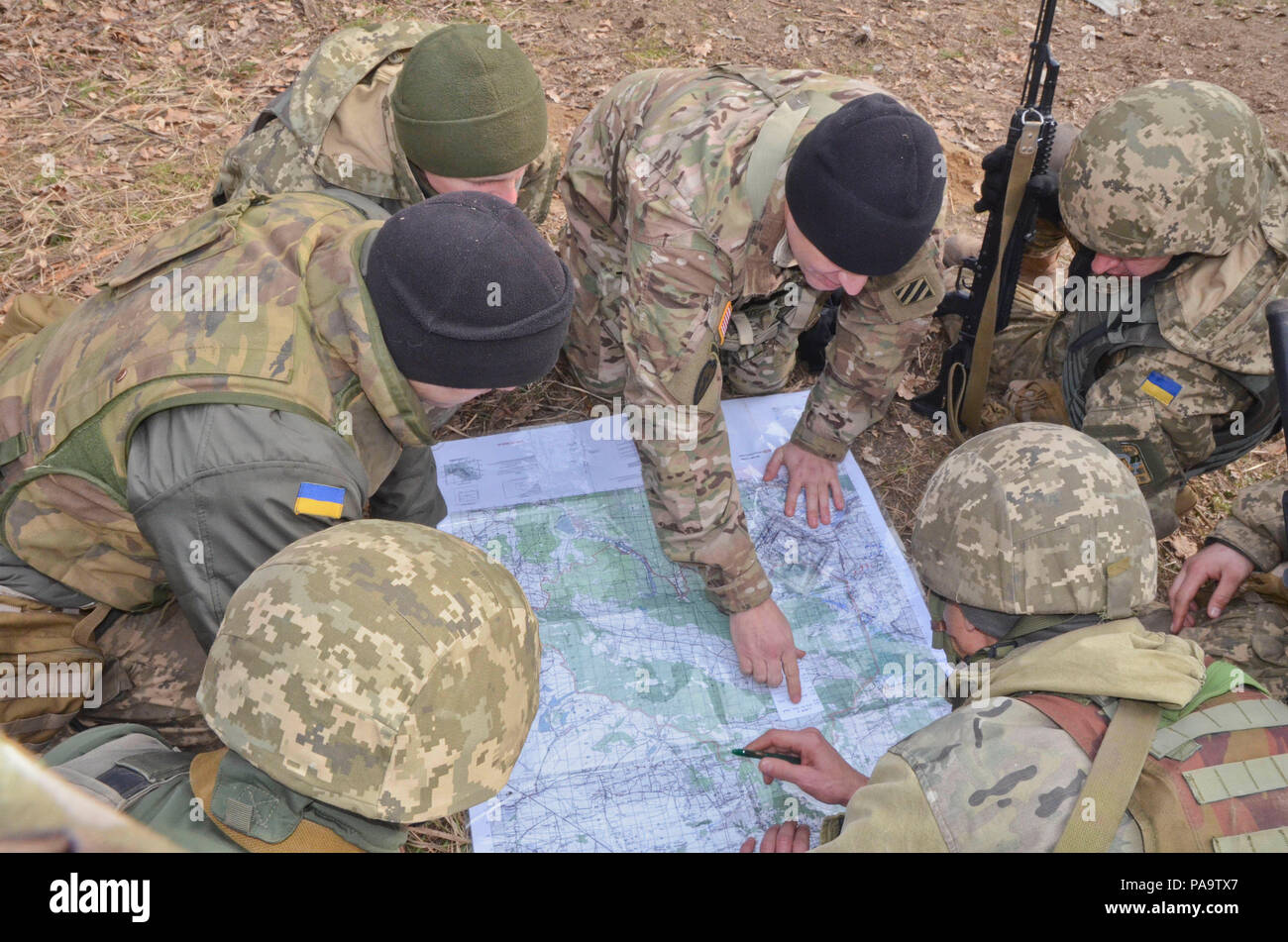 Il personale Sgt. Curtis Chancey (centro), un fante con il 3° Battaglione, xv Reggimento di Fanteria, seconda della brigata di fanteria combattere la squadra, terza divisione di fanteria insegnare ai soldati con l'esercito ucraino come determinare la griglia di coordinate di un punto su una mappa il 5 marzo 2016, durante una classe sulla mappa di lettura e di navigazione terrestre in corrispondenza internazionale per il mantenimento della pace e della sicurezza Centro vicino Yavoriv, Ucraina come parte del comune di formazione multinazionale Group-Ukraine. Ogni JMTG-U la rotazione sarà composto di nove settimane di addestramento in cui soldati ukrainiens impareranno combattimento difensivo le competenze necessarie per aumentare l'Ucraina cap Foto Stock