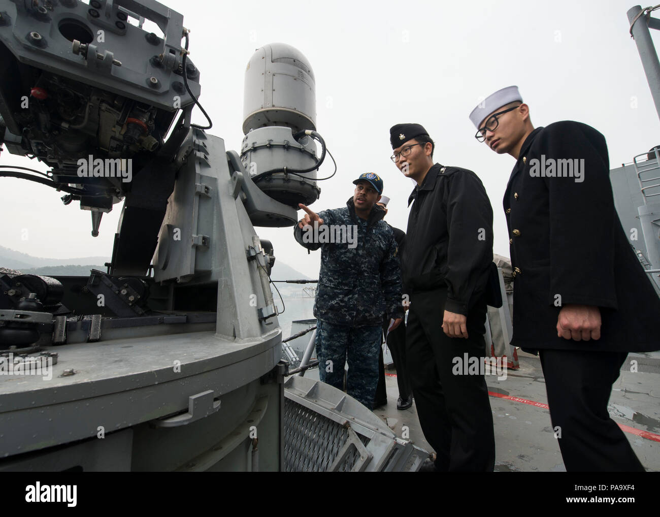 160305-N-KB CHINHAE426-061, Repubblica di Corea (5 marzo 2016) - Tenente j.g. Benjamin W. Rathwell spiega le funzioni del dock anfibio sbarco nave USS Germantown (LSD 42) 25mm mitragliatrice alla Repubblica di Corea (ROK) marinai della marina durante un tour della nave. Germantown è assegnato al Bonhomme Richard Expeditionary Strike gruppo (BHRESG) e sta conducendo una pattuglia di routine nel 7 ° Flotta area di operazioni lungo con il avviato 31 Marine Expeditionary Unit (MEU). (U.S. Foto di Marina di Massa lo specialista di comunicazione di terza classe James Vazquez/rilasciato) Foto Stock