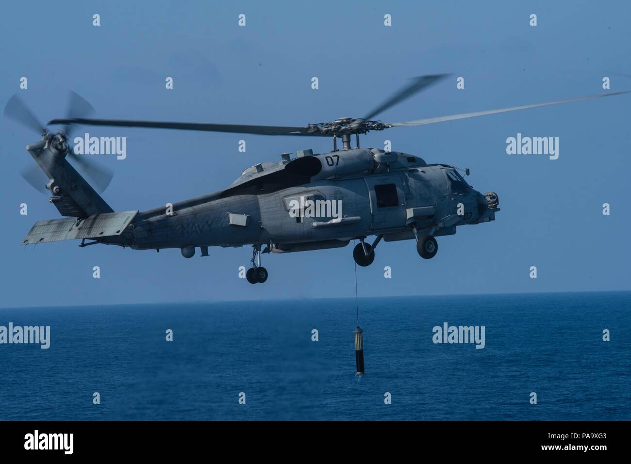 160307-N-GZ947-508 Mare delle Filippine (7 marzo 2016) - Un MH-60R Sea Hawk assegnato ai rapaci di elicottero Maritime Strike Squadron (HSM) 71 si abbassa un sonar di immersione in acqua accanto a USS John C. Stennis (CVN 74) durante un aria di dimostrazione di potenza. Fornire una forza di pronto il supporto di sicurezza e stabilità nella Indo-Asia-pacifico, Stennis è operativo come parte del grande parco verde su un pianificate regolarmente 7 Distribuzione flotta. (U.S. Foto di Marina di Massa lo specialista di comunicazione di terza classe Kenneth Rodriguez Santiago / rilasciato) Foto Stock