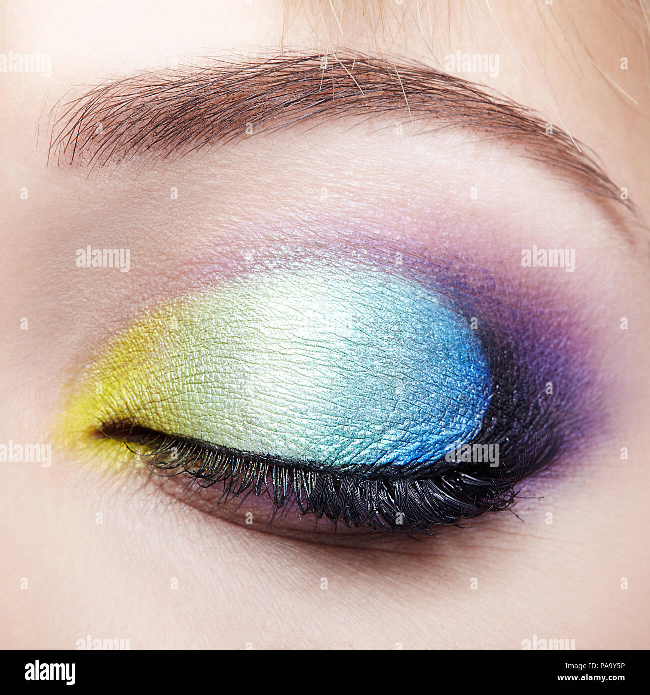 Macro Closeup colpo di umano chiuso occhio femmina con i colori giallo e blu trucco Foto Stock