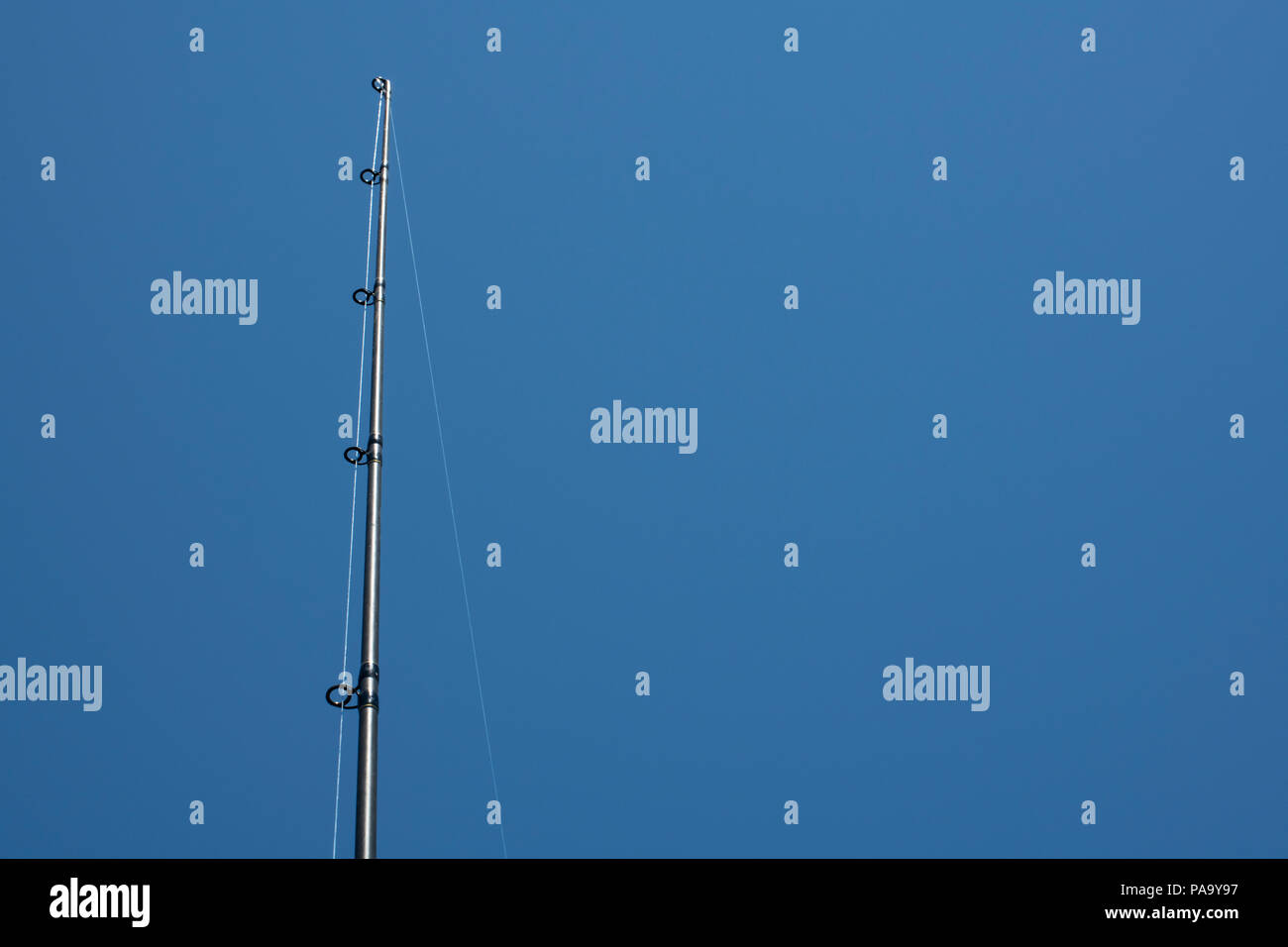 Una canna da pesca contro un profondo cielo blu. Foto Stock