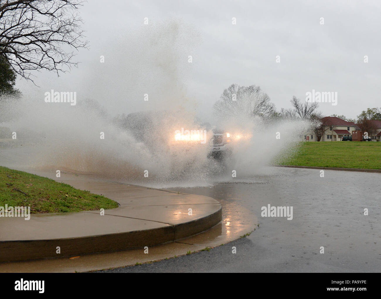 Un veicolo spinge attraverso acqua pesante nel mezzo di inondazione condizioni a Barksdale Air Force Base, La., 9 marzo 2016. Allagamenti spazzato il ArkLaTex regione, dove alcune aree visto più di 25 centimetri di pioggia nel corso di un periodo di tre giorni. È stato dichiarato uno stato di emergenza oltre 16 Louisiana parrocchie. Centinaia di Bossier famiglie sono state costrette ad abbandonare le loro case come obbligatori le evacuazioni erano stati ordinati per nove quartieri.(STATI UNITI Air Force foto/Airman 1. Classe Curt Spiaggia) Foto Stock