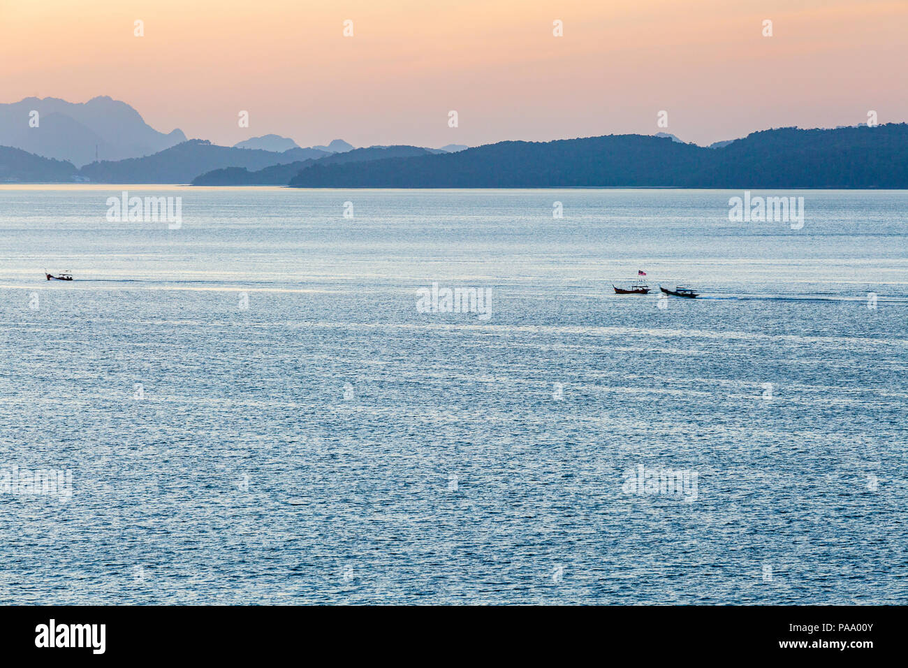 Barche da pesca race home all'alba dopo una notte fuori sul Mare delle Andamane Foto Stock