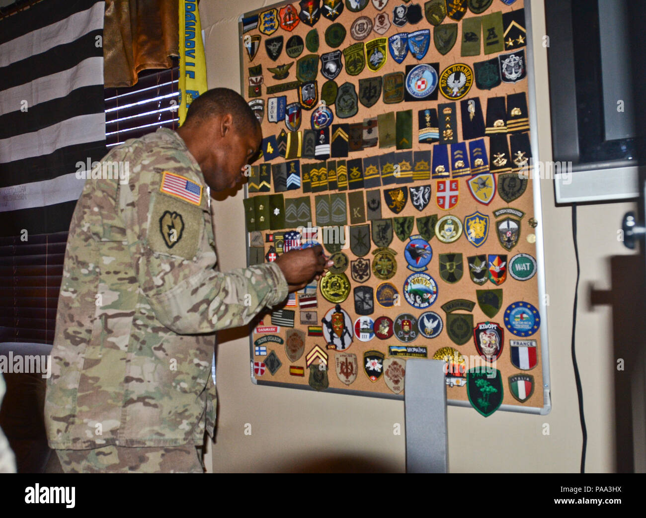 Stati Uniti Army Sgt. 1. Classe Raymond Robinson, un ferro da stiro truppa sergente di plotone con terzo squadrone, 2° reggimento di cavalleria di stanza al di fuori del Vilseck, Germania, originariamente da Bowling green, Ky., luoghi una unità patch sul muro della patch" nella officer's lounge durante la sua visita al War College a Tartu, Estonia, Marzo 18, 2016. (Foto di U.S. Il personale dell'esercito Sgt. Steven M. Colvin/rilasciato) Foto Stock