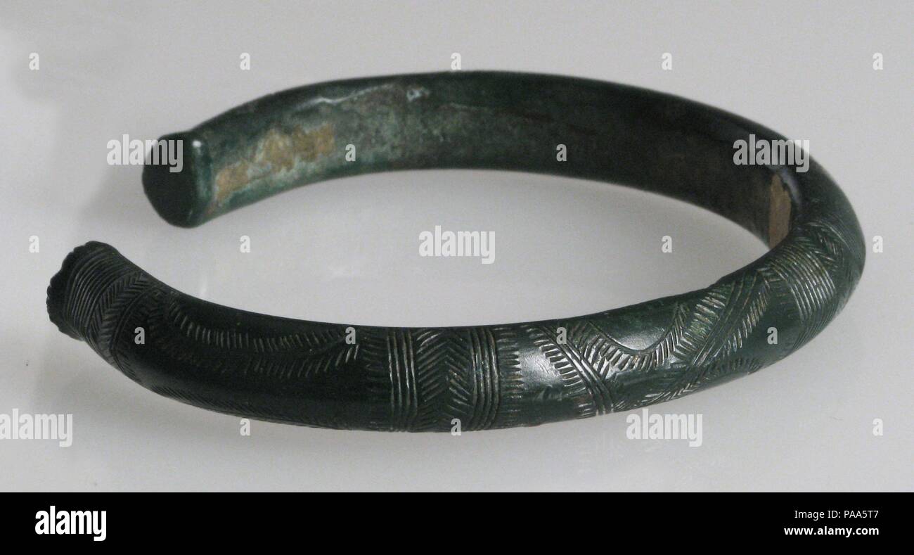 Bracciale. Cultura: Halstatt. Dimensioni: complessivo: 1/2 x 3 3/4 x 3 3/16 in. (1,2 x 9,6 x 8,1 cm). Data: ca. 800 A.C.. Molte Età del Bronzo gli oggetti, come questi bracciali sono stati finiti con sottili disegni geometrici incisi nel metallo colato superficie. Museo: Metropolitan Museum of Art di New York, Stati Uniti d'America. Foto Stock