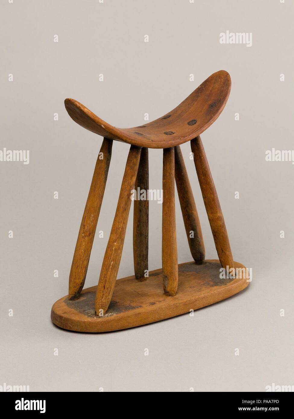 Poggiatesta. Dimensioni: H. 8 3/4 in. (22,2 cm), W. 9. (22,9 cm). Dynasty: tarda dinastia 11 - Dynasty 12. Data: ca. 2030-1802 A.C. I poggiatesta sono stati utilizzati dagli antichi egizi per supportare una persona il collo durante il sonno. Mentre il piatto della scheda di base e di sommità curvata sono funzioni omogenee, la forma della sezione centrale varia. Questo tipo con sei sottili aste di supporto della sommità curvata è abbastanza raro. Più comuni sono stati singola colonna-come sostiene tra la base e la sommità. Museo: Metropolitan Museum of Art di New York, Stati Uniti d'America. Foto Stock