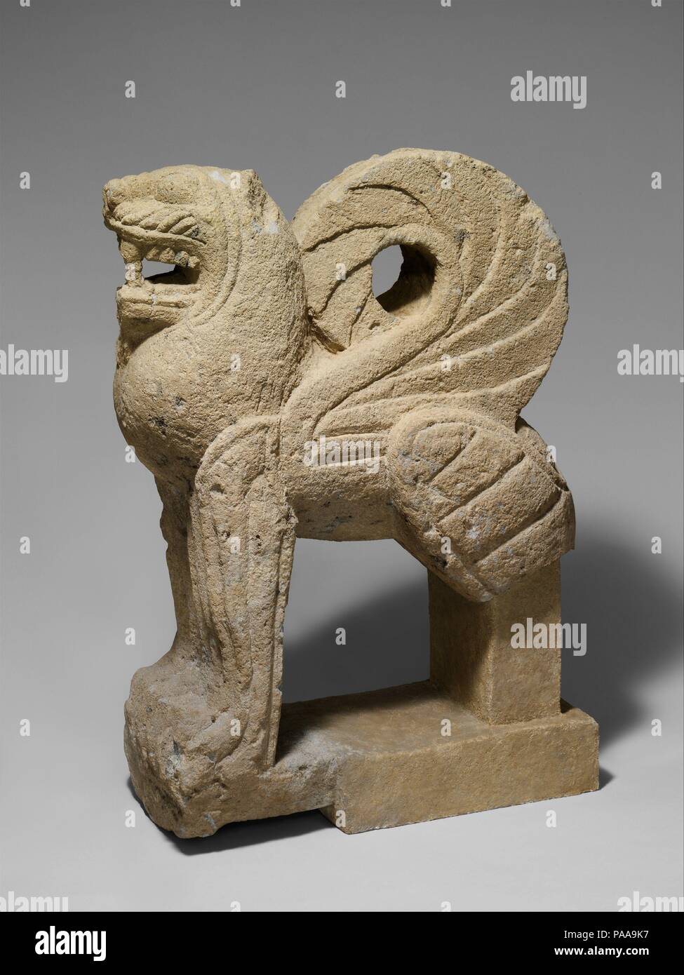 Nenfro statua di un leone alato. La cultura etrusca. Dimensioni: H. 37 1/2 in. (95,3 cm); lunghezza 28 3/4 in. (73 cm); larghezza a haunches 13 3/4 in. (35 cm). Data: ca. 550 A.C. Diverse statue di questo tipo, realizzata in nenfro, una sorta di pietra vulcanica usato estensivamente in corrispondenza di Vulci, raffigurano leoni alati e sfingi. Questi sono stati impostati per proteggere gli accessi alla camera sotterranea tombe coperte da un tumulo (tumulo di terracotta). Essi spesso appaiono in coppie e rappresentano la risposta degli Etruschi a una lunga tradizione di custode figure che risale all'antico Egitto e nel Vicino Oriente. Museo: Metropolitan Mus Foto Stock