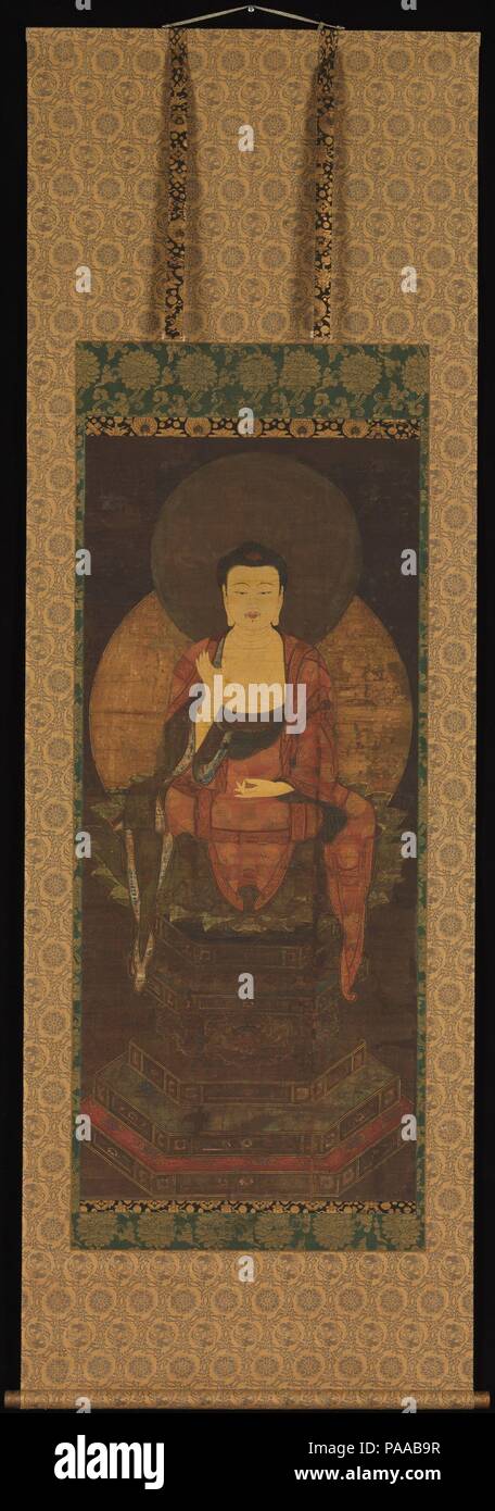 Shaka nyorai. Cultura: il Giappone. Dimensioni: Immagine: 50 1/2 × 21 a. (128.3 × 53,3 cm) complessivamente con il montaggio: 85 1/2 × 28 a. (217,2 × 71,1 cm) in generale con le manopole: 85 1/2 × 30 1/8 in. (217,2 × 76,5 cm). Data: XIV secolo. Shaka Nyorai o lo storico Buddha Shakyamuni (il saggio della tribù Shakya che hanno raggiunto l'illuminazione), ha vissuto in India da circa 563 a 483 A.C. Egli è raffigurato qui seduti a gambe incrociate su una lotus trono al di sopra di una cinque-tiered piedistallo esagonale. La maggior parte dottrina fondamentale del Buddismo, girando la ruota della legge, si concretizza nella Shaka la mano gesto il mudra di prea Foto Stock