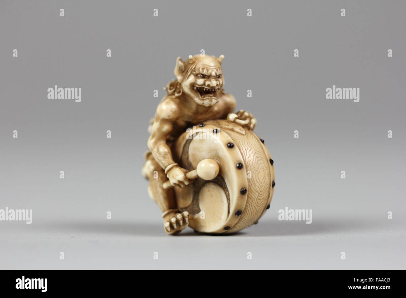 Netsuke del demone con un tamburo. Cultura: il Giappone. Dimensioni: H. 1 3/4 in. (4.4 cm); W. 1 1/2 in. (3,8 cm); D. 1 1/8 in. (2.9 cm). Data: XVIII-XIX secolo. Museo: Metropolitan Museum of Art di New York, Stati Uniti d'America. Foto Stock