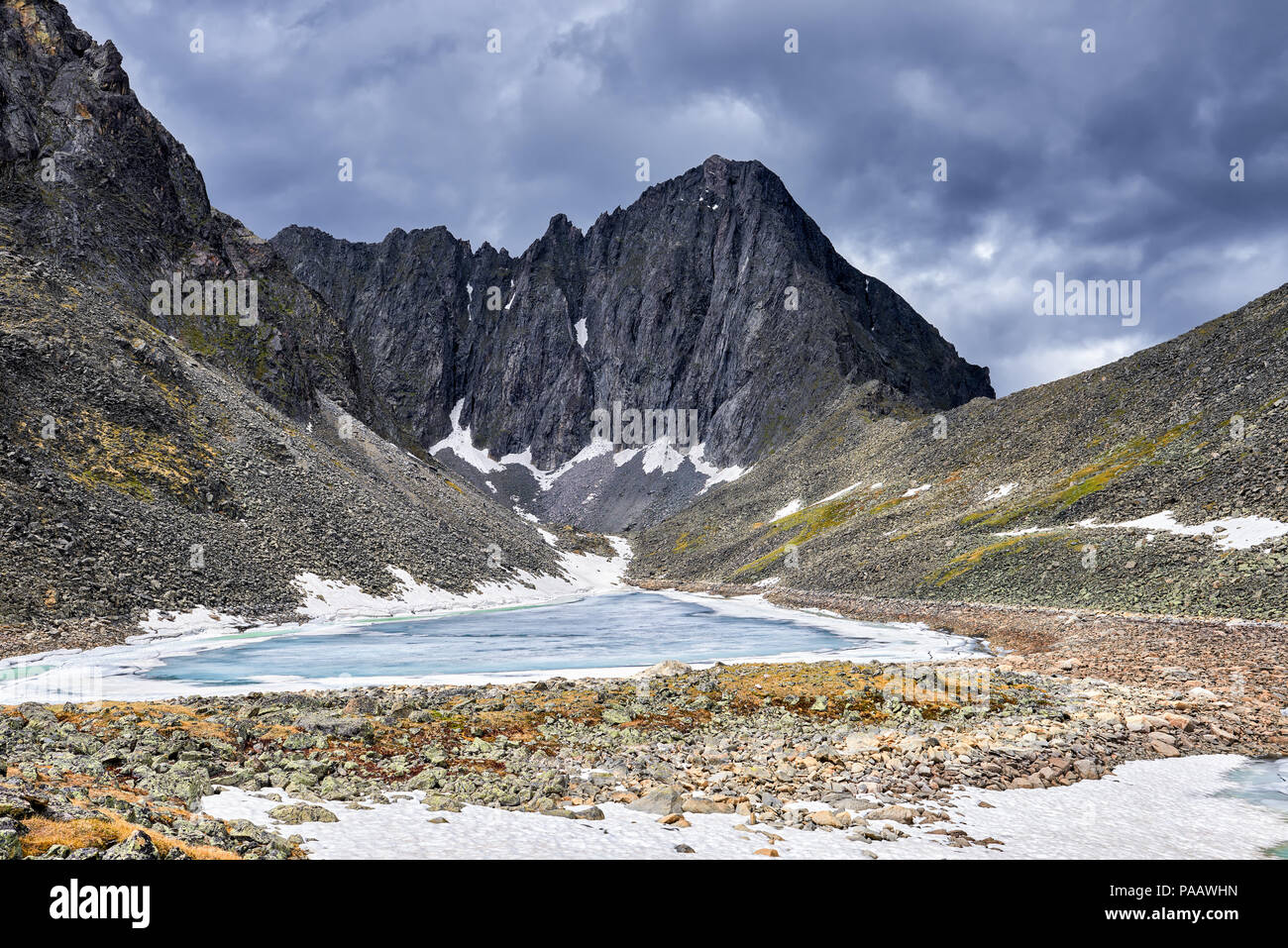 Lago ghiacciato in montagna circus davanti a picco. Oriente Sayan. La Russia Foto Stock