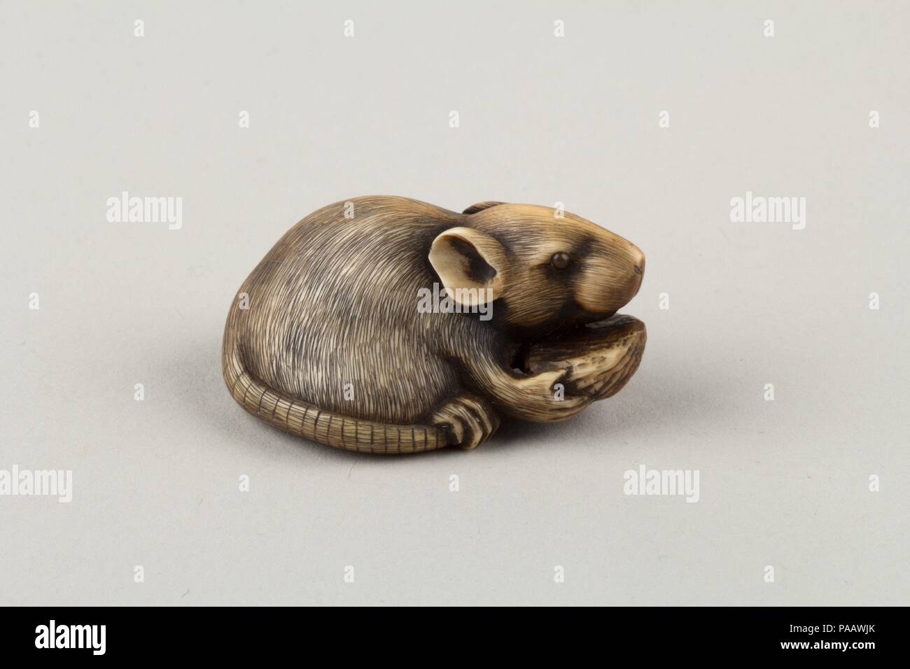 Netsuke del Mouse di mangiare una fossa. Cultura: il Giappone. Dimensioni: H. 3/4 in. (1,9 cm); W. 1 1/2 in. (3,8 cm); D. 1. (2.5 cm). Data: del XIX secolo. Museo: Metropolitan Museum of Art di New York, Stati Uniti d'America. Foto Stock