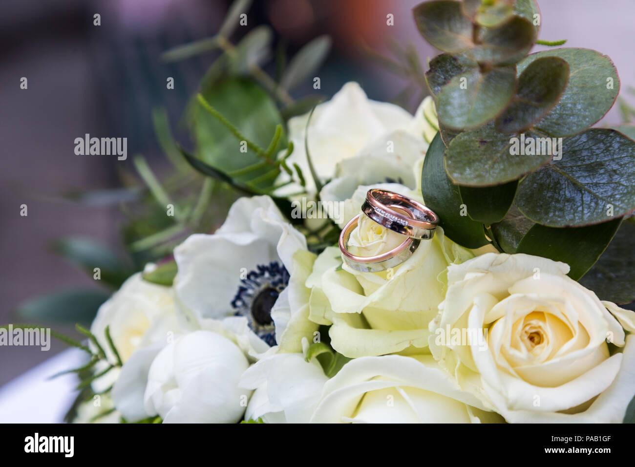 Bouquet di rose e gli anelli che giace sul tavolo Foto Stock