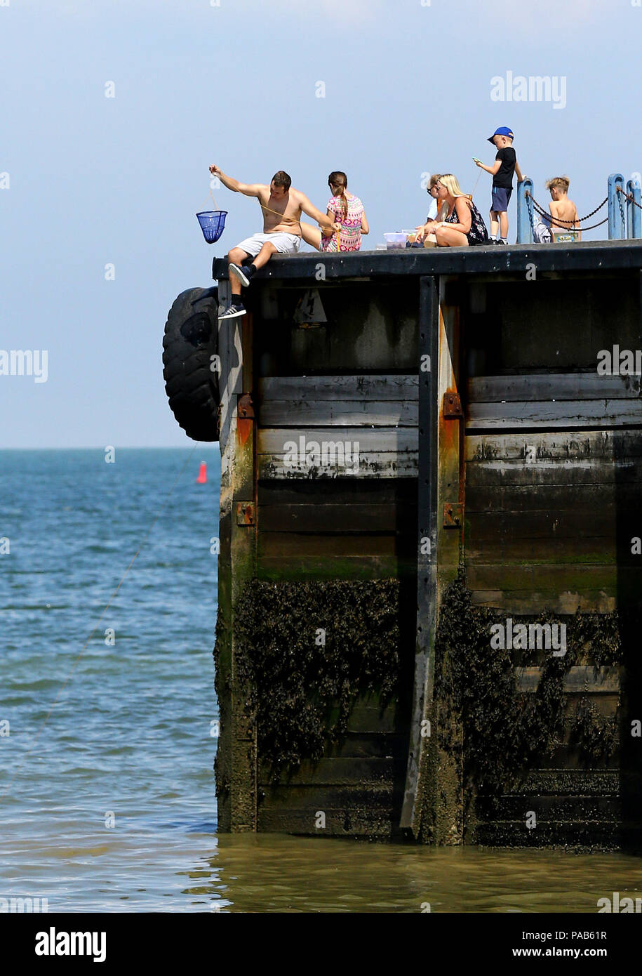 Le persone godono di un clima caldo e sulla spiaggia di whitstable kent, come il clima caldo continua. Foto Stock