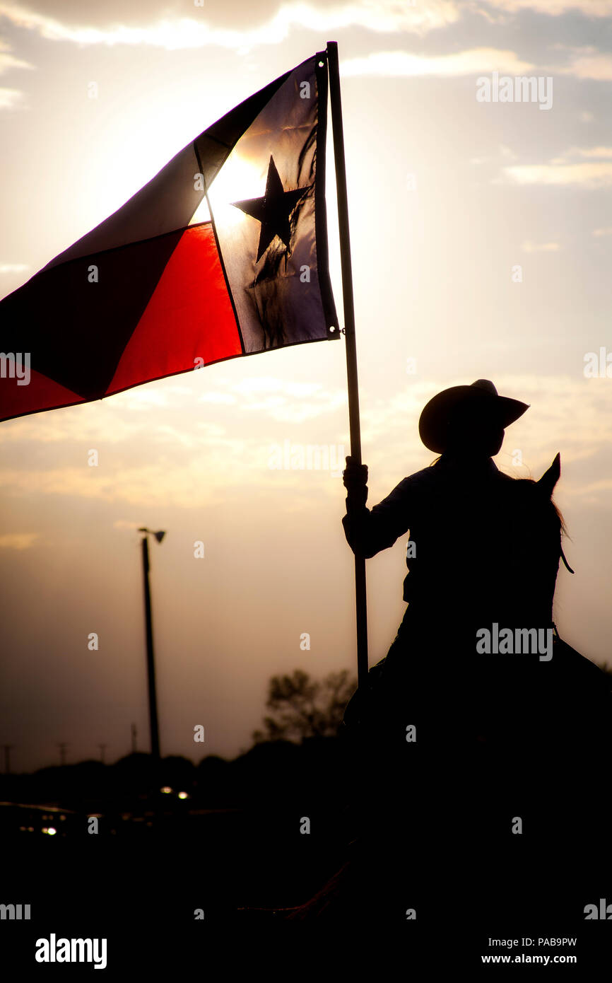Cowgirl con Texas bandiera a gran voce in un ranch rodeo concorrenza. Foto Stock