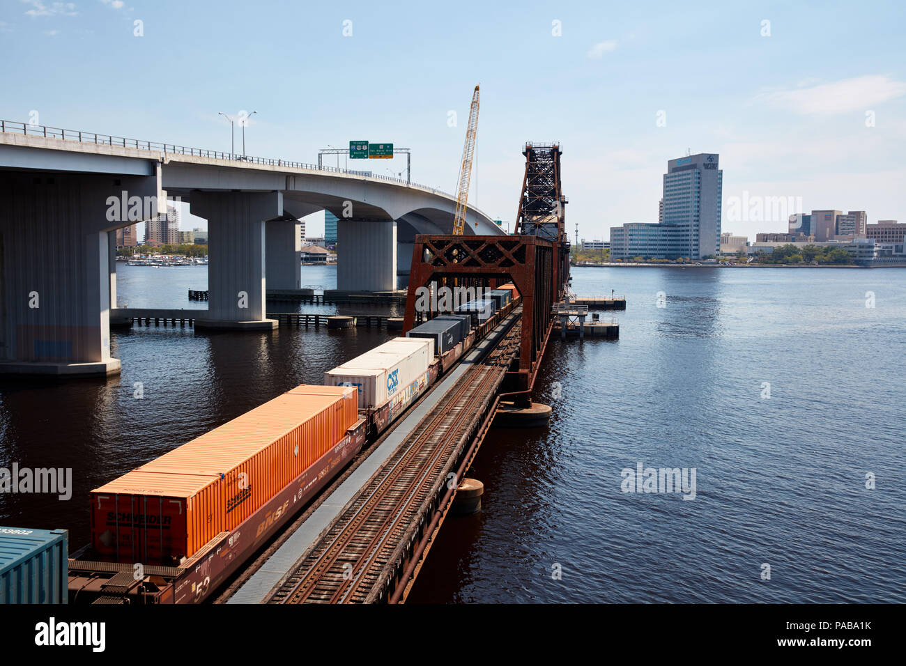 Treno caricato con i contenitori di spedizione attraversando il fiume del St Johns a Acosta bridge a Jacksonville, Florida Foto Stock