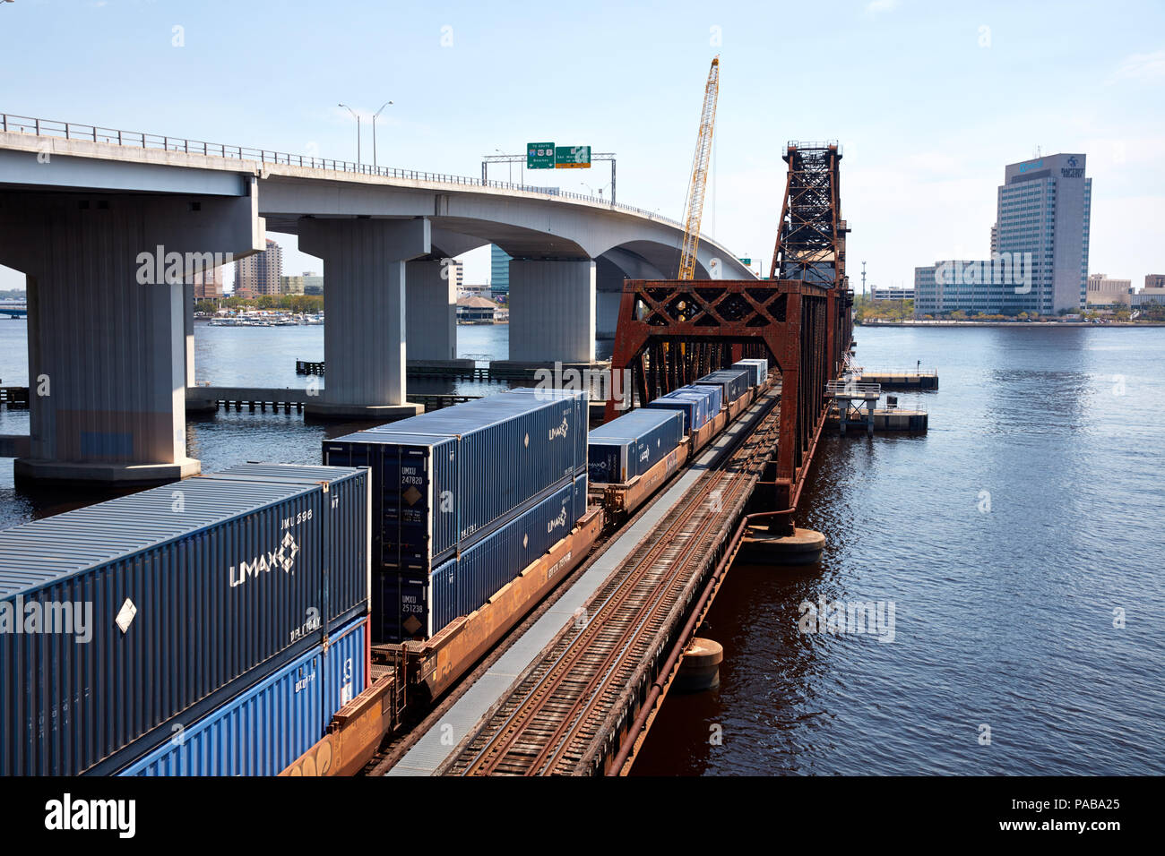 Treno caricato con i contenitori di spedizione attraversando il fiume del St Johns a Acosta bridge a Jacksonville, Florida Foto Stock