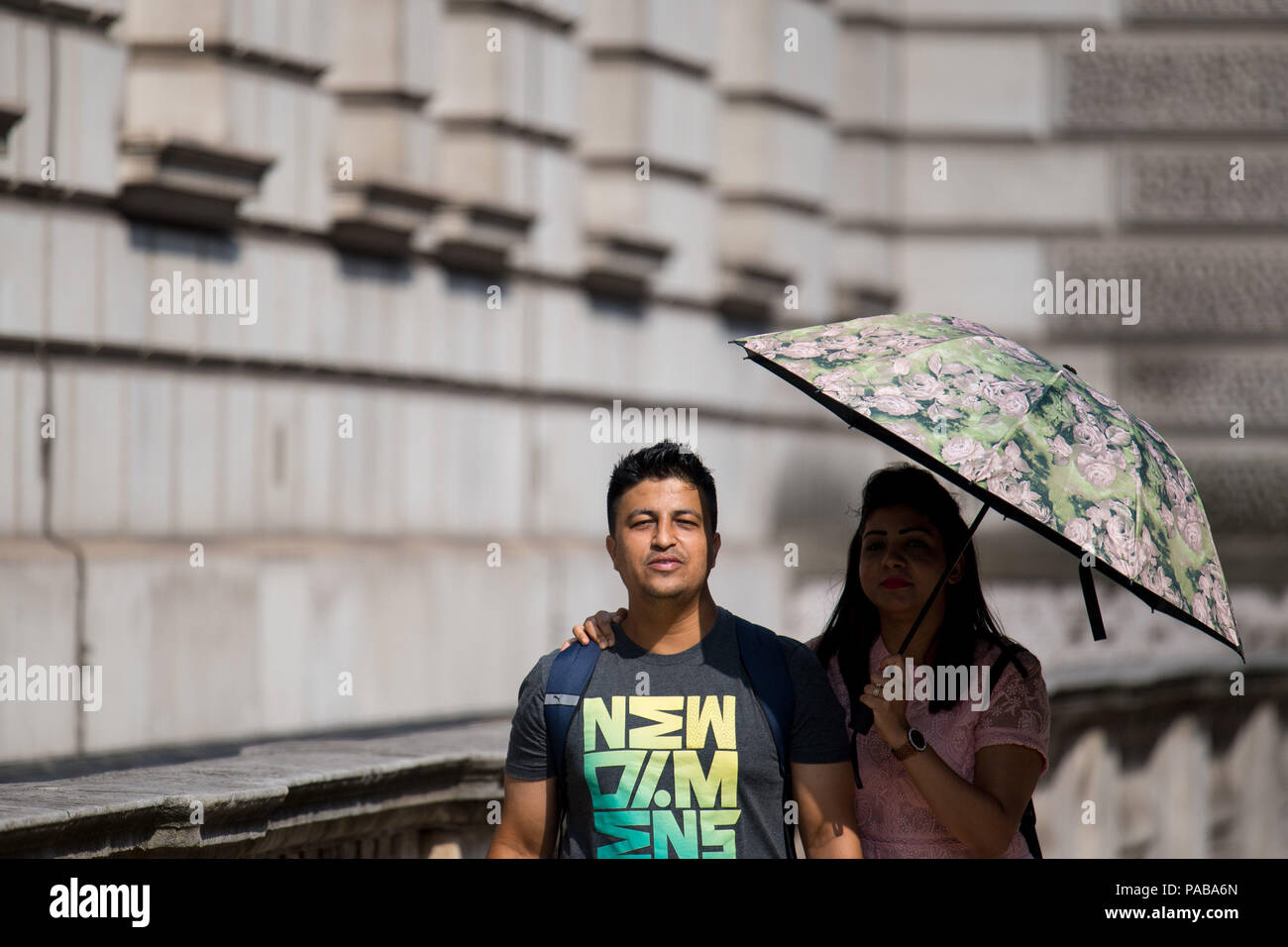 Le persone utilizzano un ombrello per ripararsi dal sole in Westminster,  Londra, così come il clima caldo continua Foto stock - Alamy