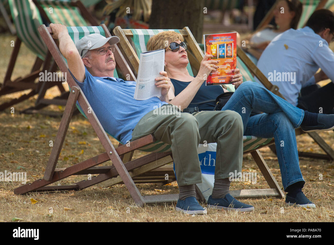 Le persone a rilassarsi nelle sedie a sdraio in St James Park di Londra, come il clima caldo continua. Foto Stock