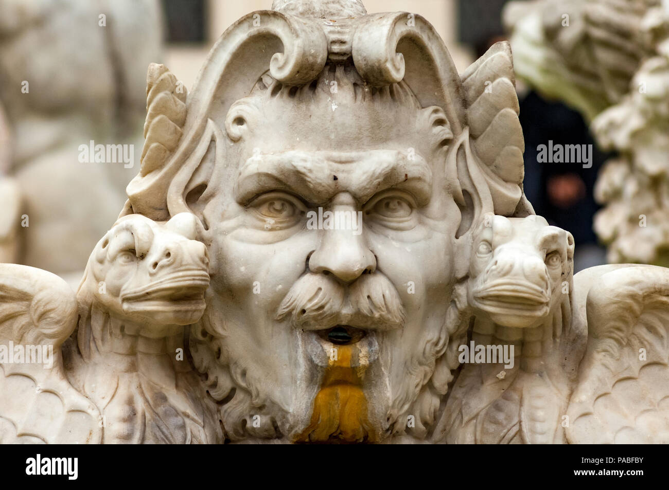 Una testa scolpita e bestie mitiche guardare fuori da la Fontana del Moro in Piazza Navona, Roma Foto Stock
