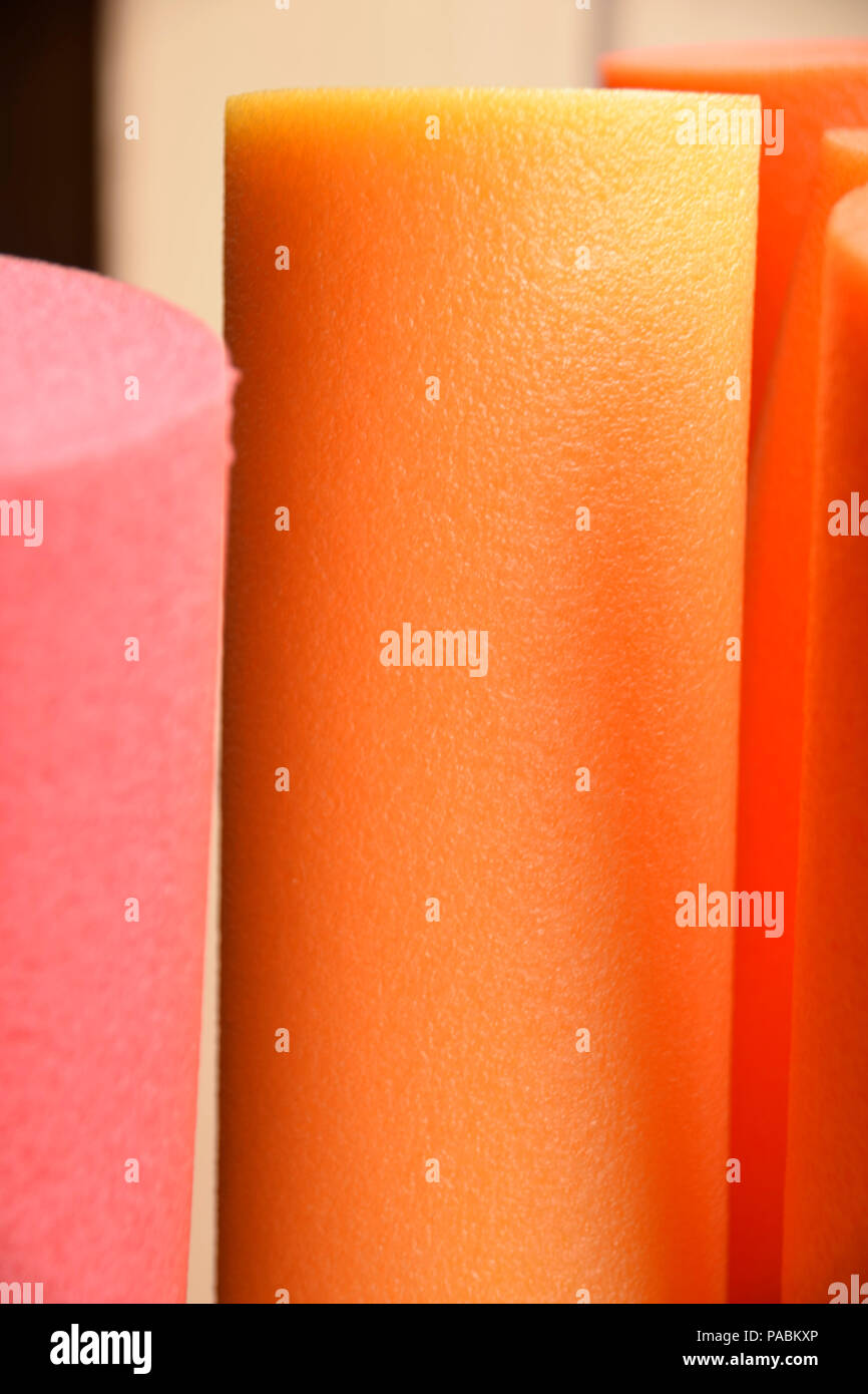 Ripresa macro di un arancio pool noodle, la piscina o la terapia o nuotare tagliatelle in colori moderni dettaglio shot Foto Stock