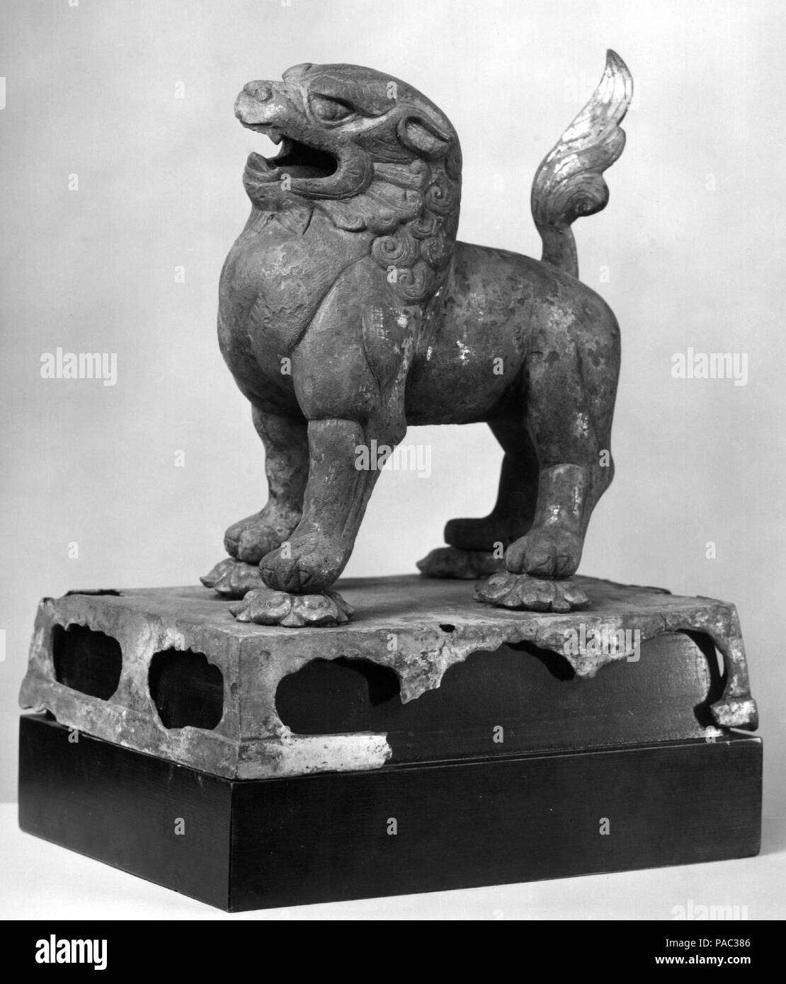 Lion permanente. Cultura: la Cina. Dimensioni: H. 9 3/4 in. (24,8 cm). Data: 8. secolo. Questo regal lion, che passi su lotus sboccia sulla cima di un altare tabella, può essere servita come attacco per una figura del bodhisattva Manjushri, il buddista di realizzazione della sapienza trascendente. Museo: Metropolitan Museum of Art di New York, Stati Uniti d'America. Foto Stock
