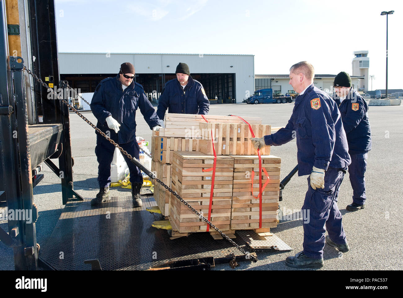 I membri di Fairfax County Fire e al dipartimento di soccorso, Va.: Virginia Task Force 1 scaricare puntellamento Marzo 3, 2016 presso il 436th porta antenna squadrone cantiere di smistamento su Dover Air Force Base, Del. il puntellamento è stato utilizzato per stabilizzare sia 48 piedi e 54 piedi di VTF 1 attrezzature e rimorchi di alimentazione dopo che essi sono stati caricati su di un C-5M Super Galaxy come parte di un esercizio di allenamento per il Team Dover personale e ricerca e salvataggio in aree urbane i membri del team. (U.S. Air Force foto/Roland Balik) Foto Stock