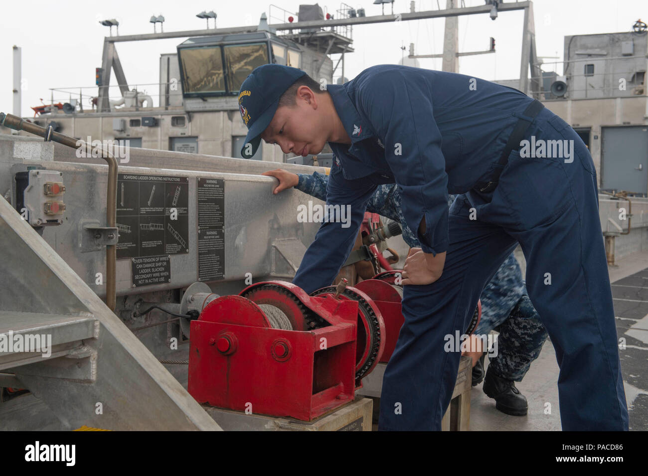 Un tecnico dell'elettronica dell'aviazione gestisce l'argano principale per sollevare la fronte a bordo della USNS Spearhead (T-EPF 1) a Douala, Camerun durante la Africa Partnership Station. La nave da trasporto veloce Expeditionary supporta le operazioni della 6th Fleet statunitense, fornendo un rapido trasporto di personale e attrezzature per l'addestramento, esercitazioni congiunte e missioni di sicurezza marittima. Il verricello agevola l’imbarco e lo sbarco in sicurezza dei veicoli e del personale, migliorando al contempo la prontezza operativa e l’interoperabilità marittima nelle acque costiere africane. Foto Stock