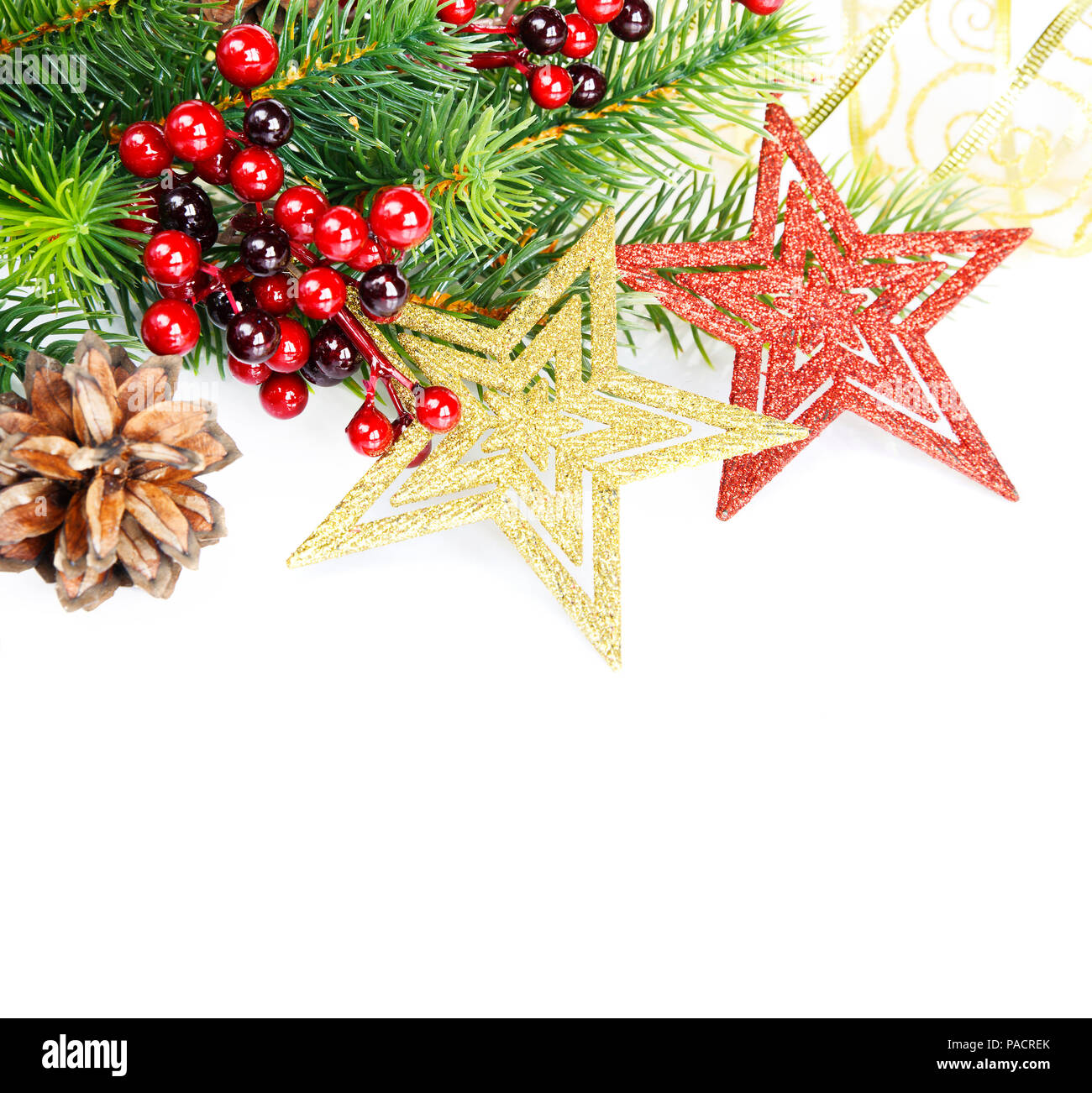 Natale compositionon verde con rami di abete rosso, holly barries, rosso e golder stelle e fir cono isolato su sfondo bianco Foto Stock